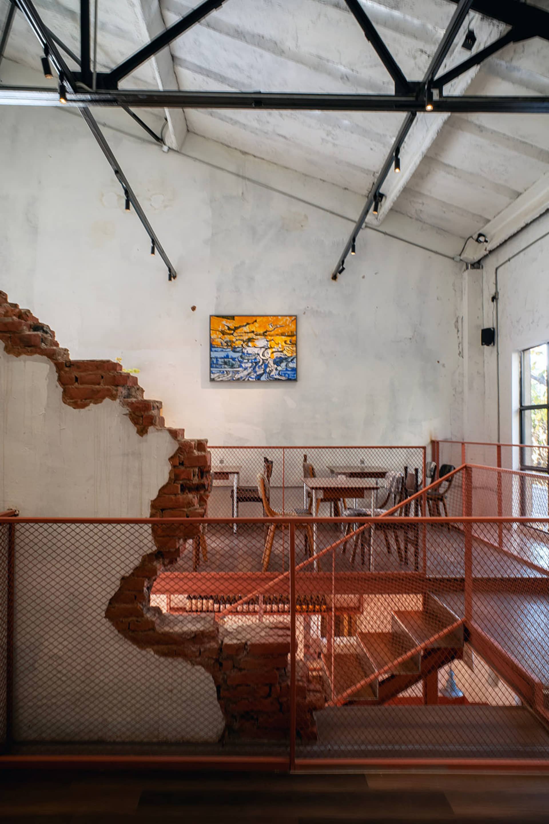 A restaurant interior with a brick wall, wooden furniture, and a mix of natural and artificial lighting, creating a cozy and inviting atmosphere