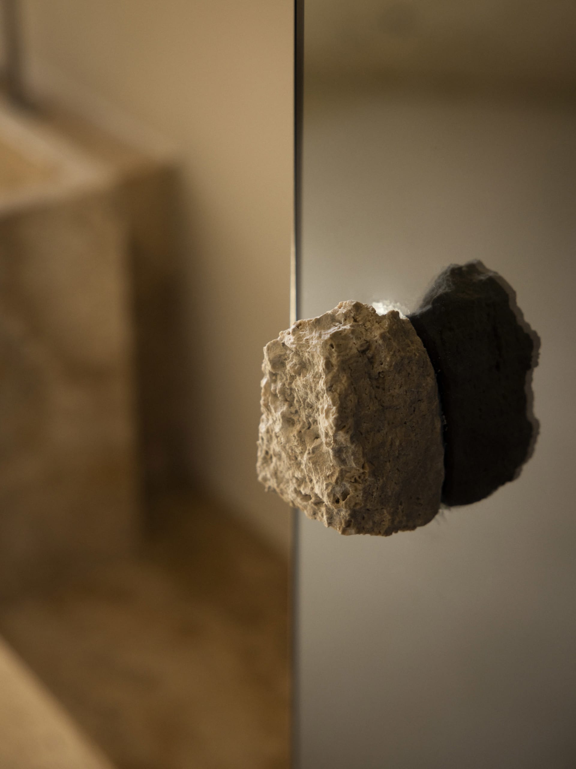 A dimly lit bathroom with a large rock in the doorway, creating a mysterious atmosphere
