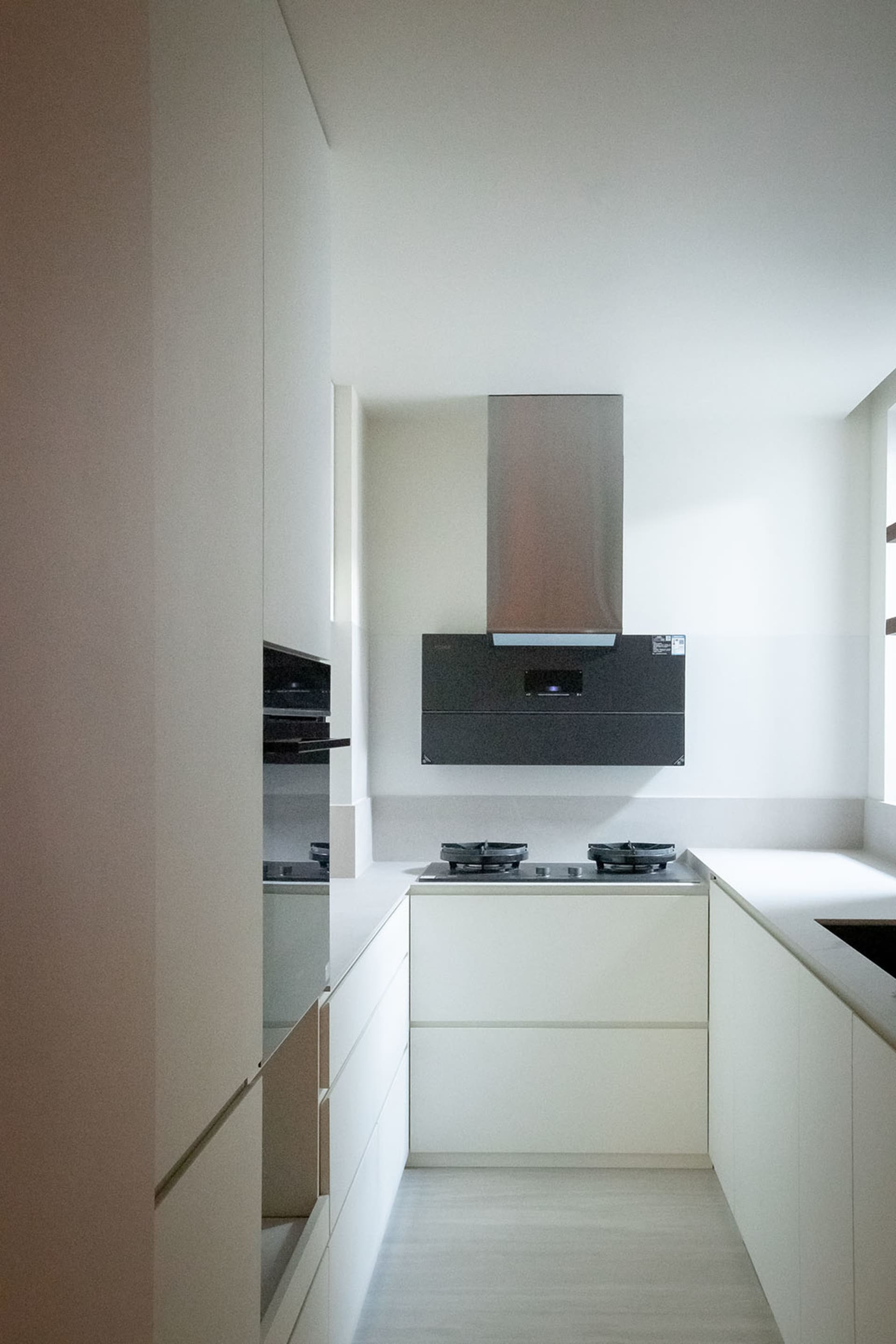 Modern kitchen with white cabinets, a black stove, and natural light from a window above the stove
