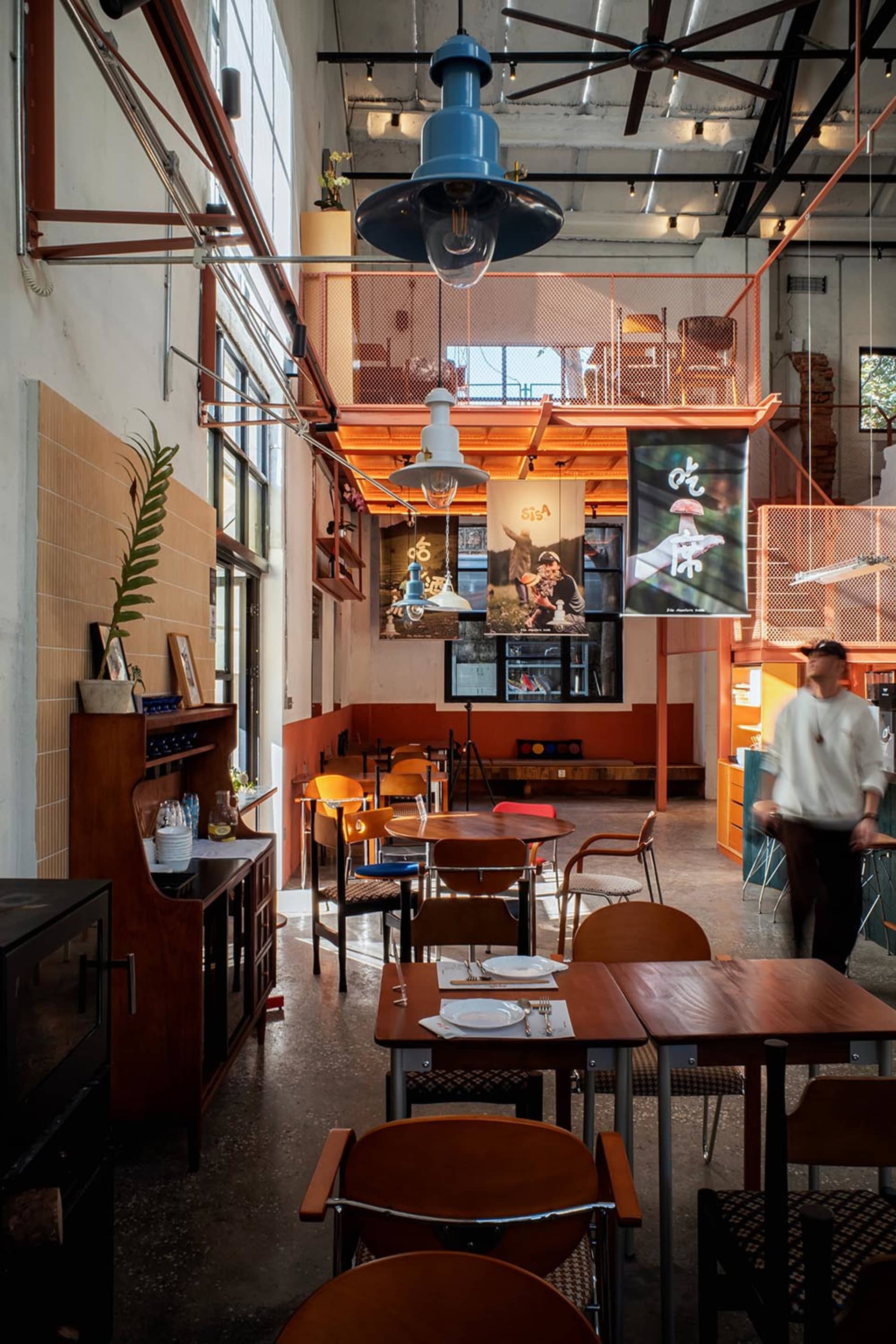Cozy restaurant with wood and metal elements, dim lighting, and tables and chairs