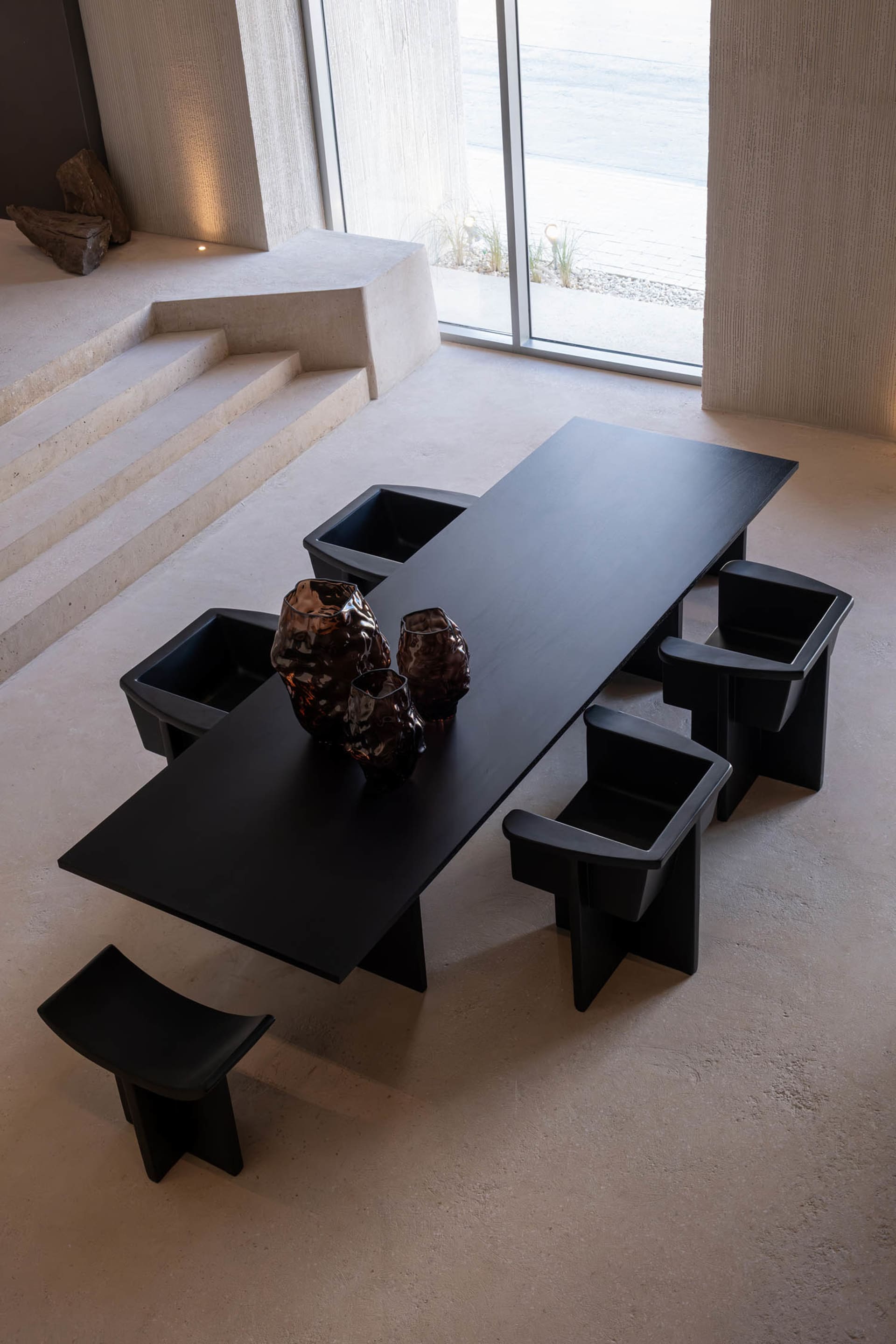 Black dining table and chairs in a modern minimalist room, encouraging conversation and interaction