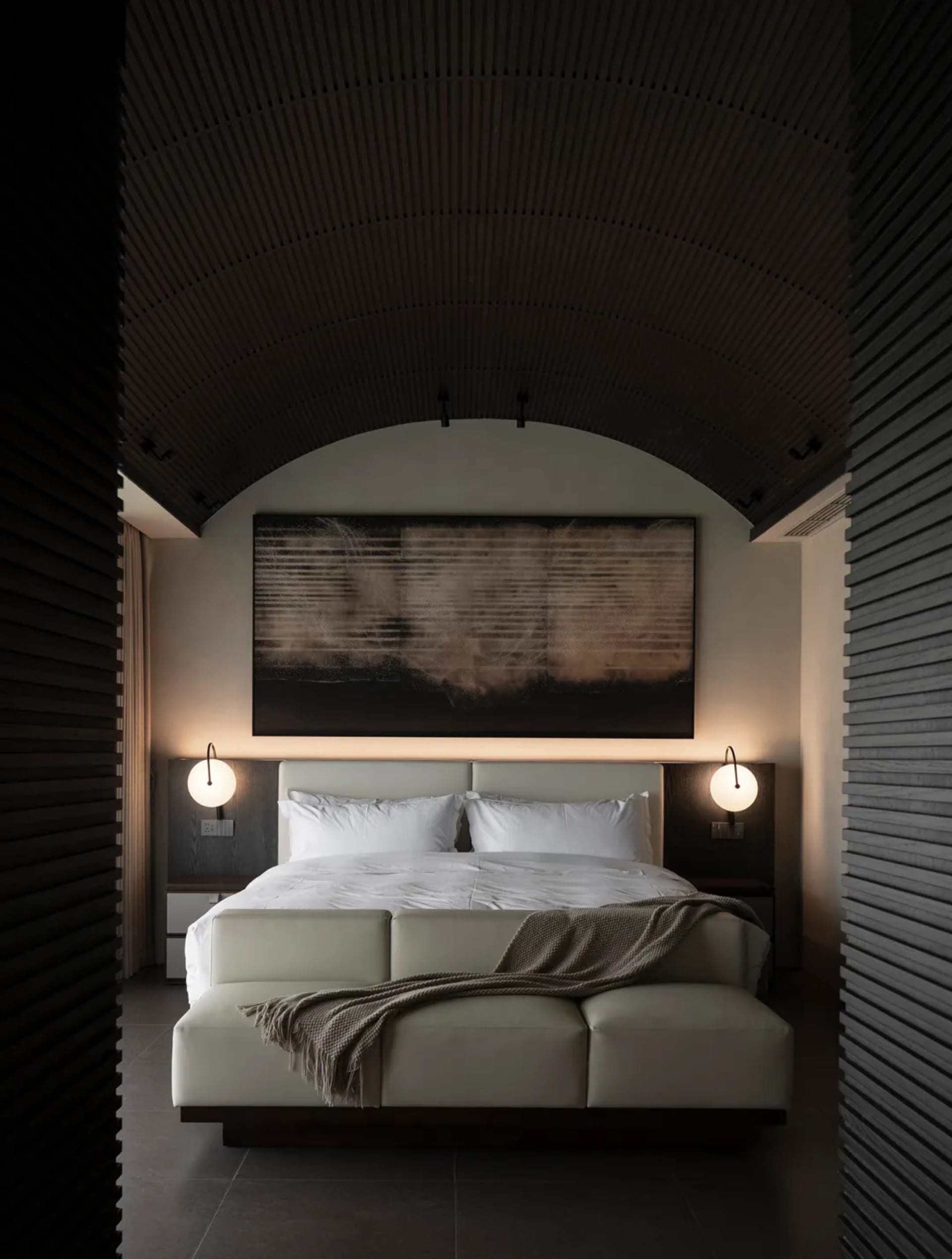 Cozy bedroom with a white bed, brown blanket, and black and white color scheme, featuring a large window for natural light