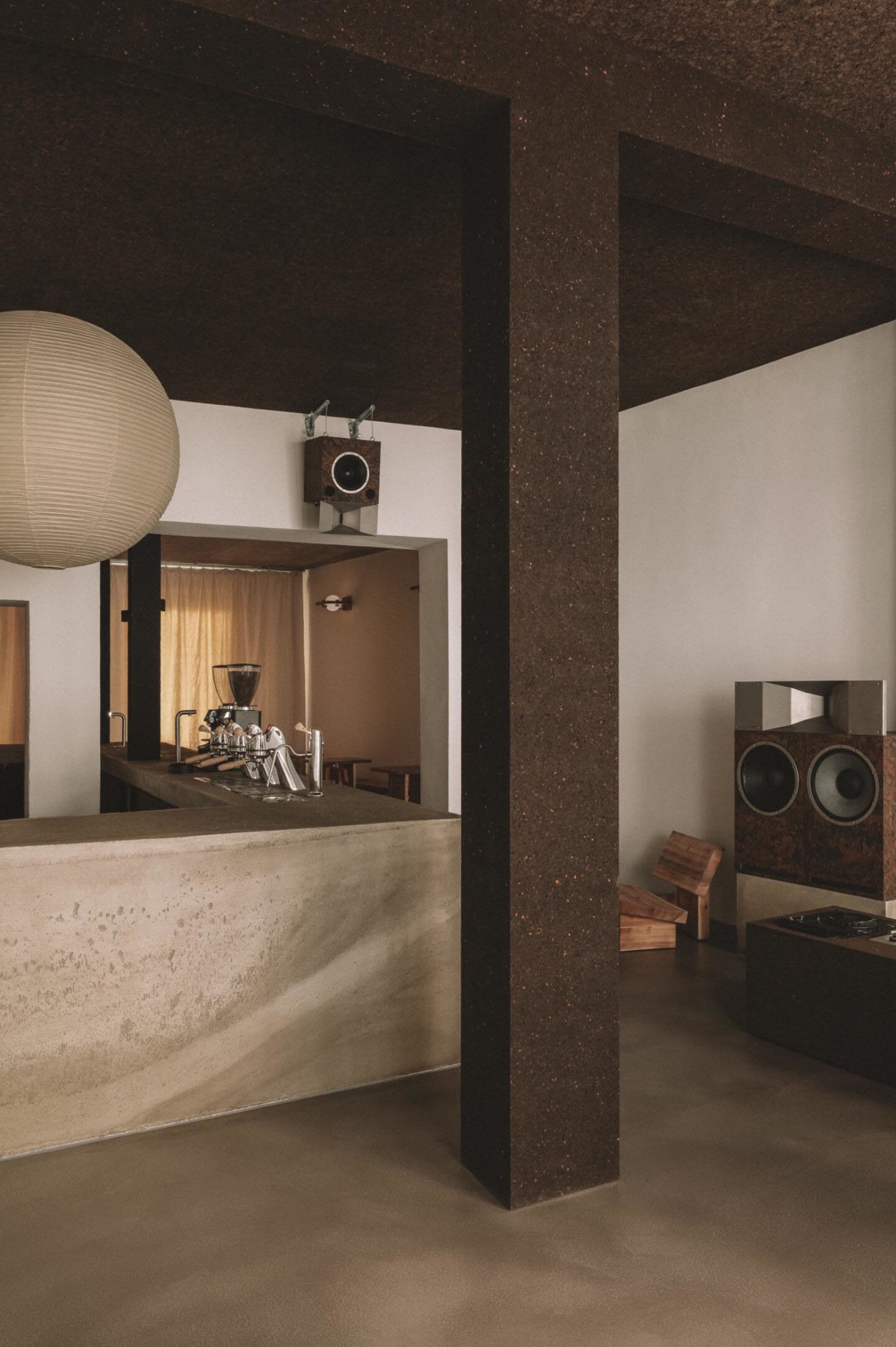 Cozy bar with a wooden chair, concrete counter, and brown and white decor, with a warm and inviting atmosphere