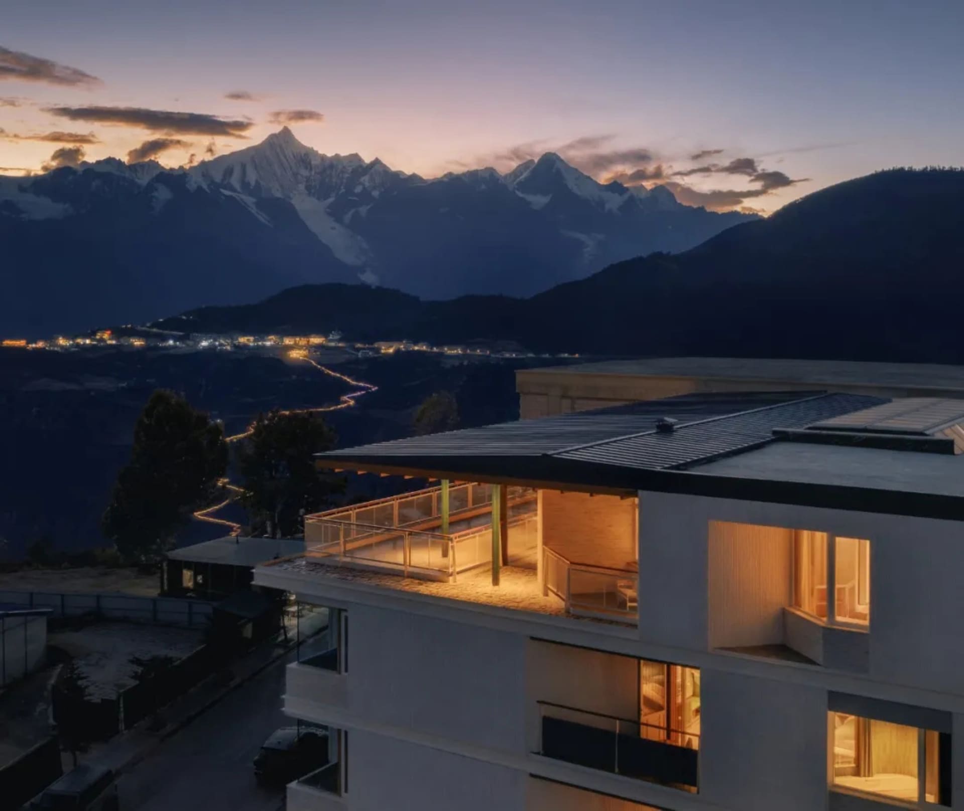 A serene and inviting modern house with a balcony on a hillside, surrounded by mountains and natural lighting