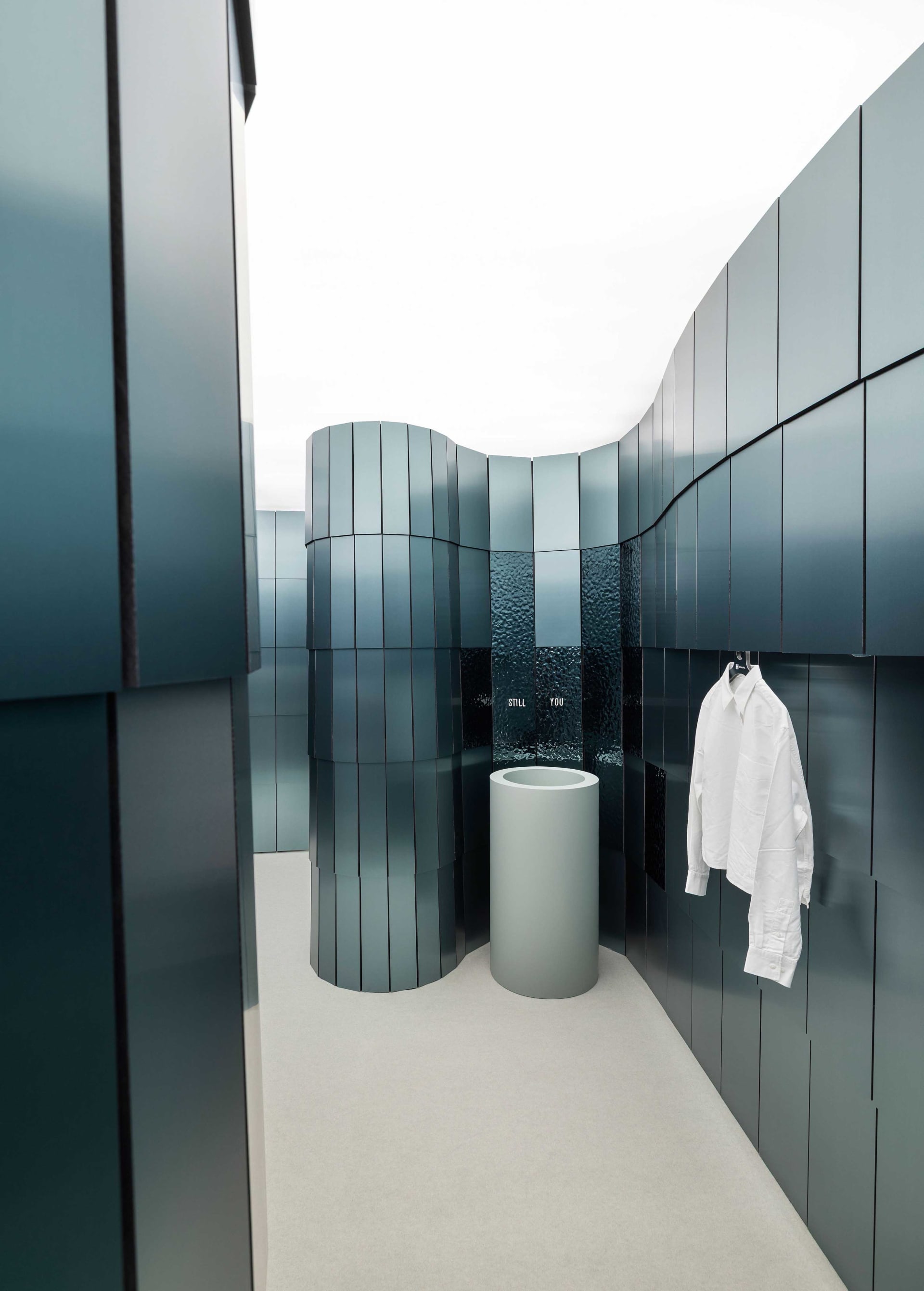A modern bathroom with a blue color scheme, featuring a sink, towel rack, and shower, with a clean and well-maintained atmosphere