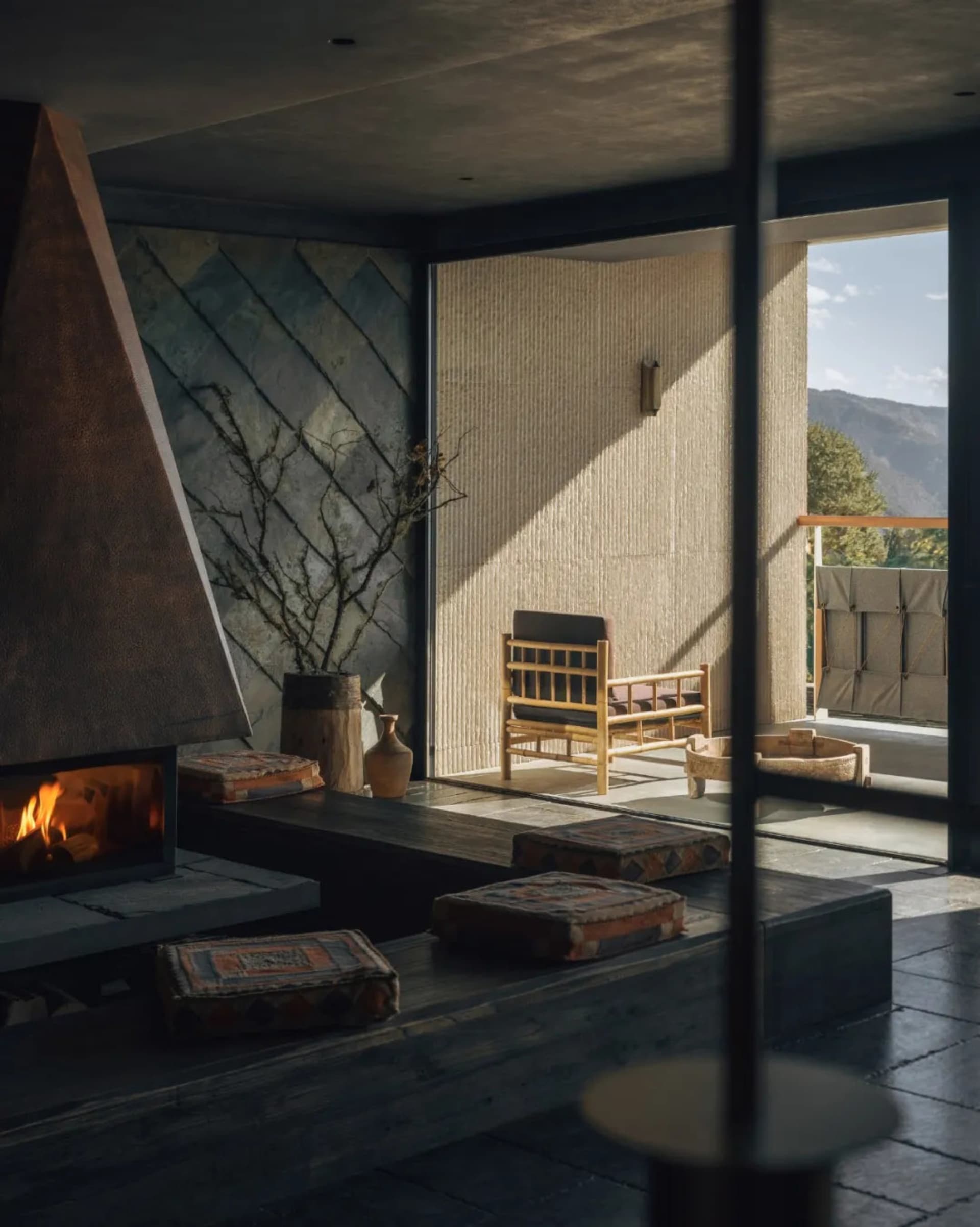 Cozy living room with a fireplace, a couch, and a chair, featuring a mix of natural and artificial lighting, and a modern functional style