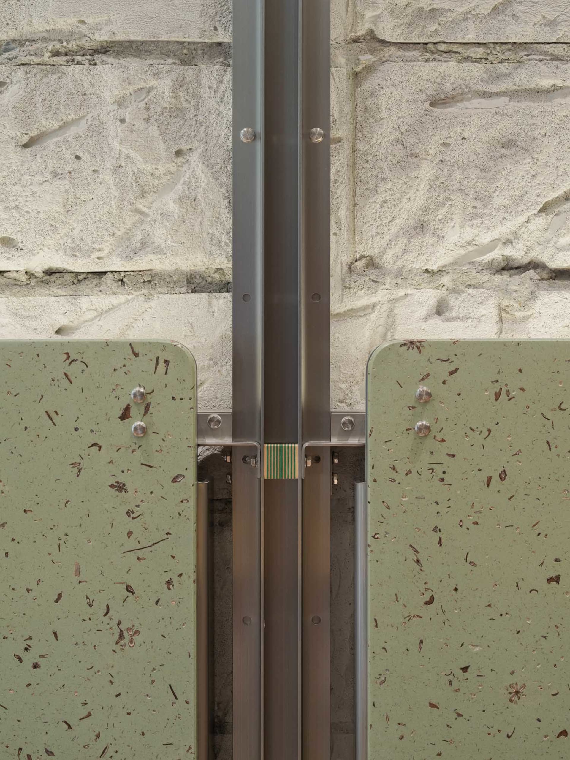 A stone wall with a metal bar attached to it, set against a warm and inviting background with natural light
