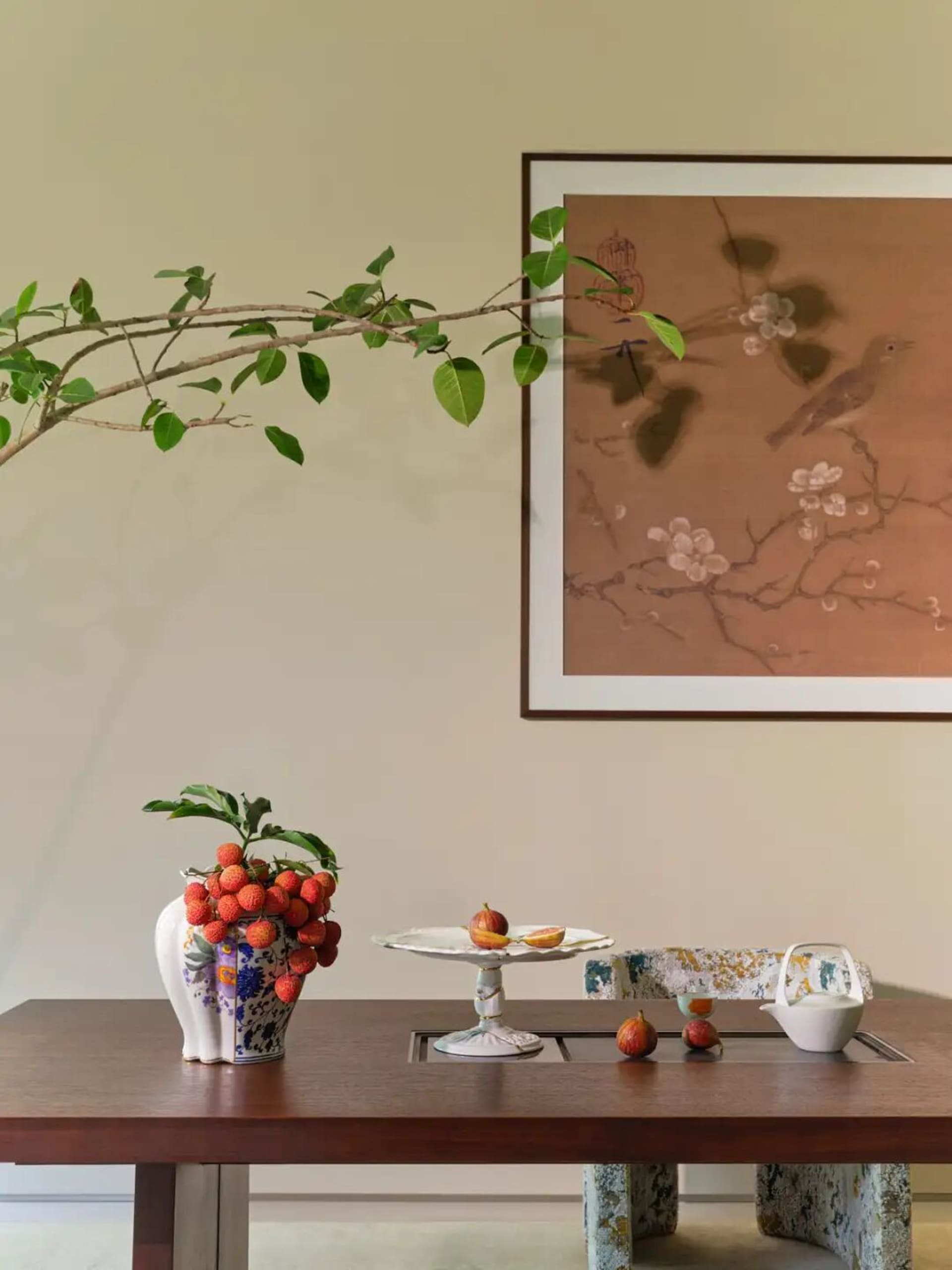 A cozy dining room with a wooden table, a vase of fruit, and a potted plant, featuring soft and warm lighting