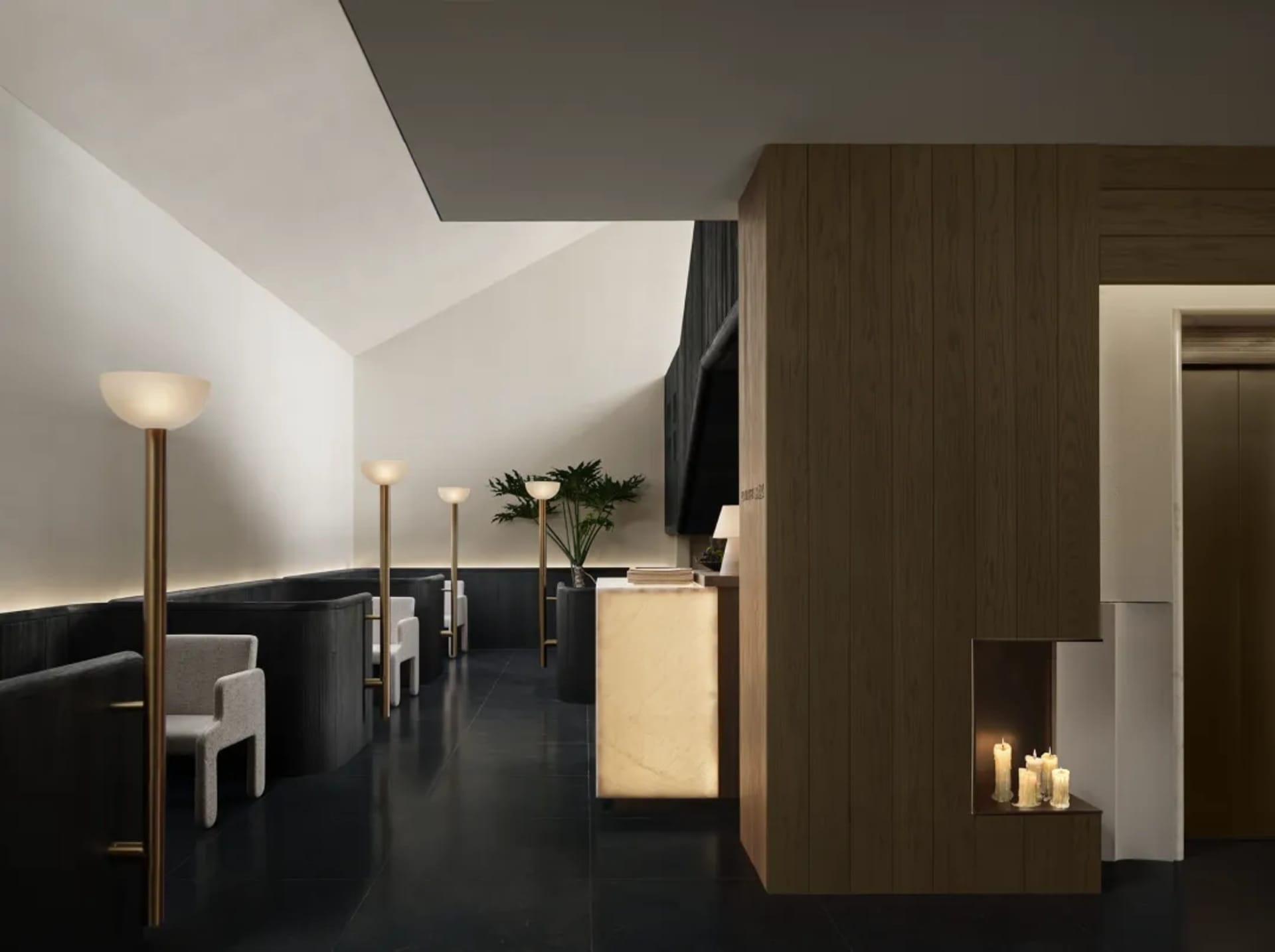 Dimly lit bathroom with a wooden door, marble counter, and sink, creating a warm and inviting ambiance