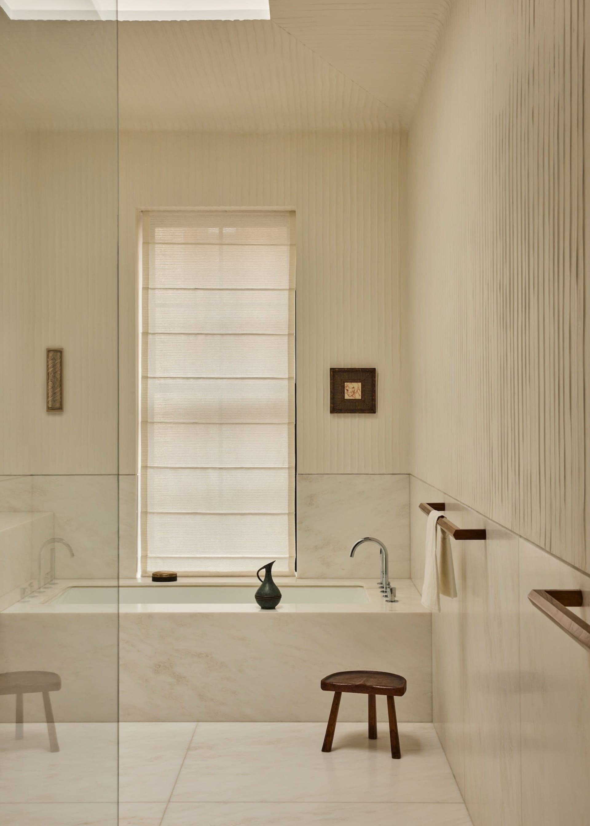 Modern bathroom with a white bathtub, natural light from a large window, and a clean, minimalistic design