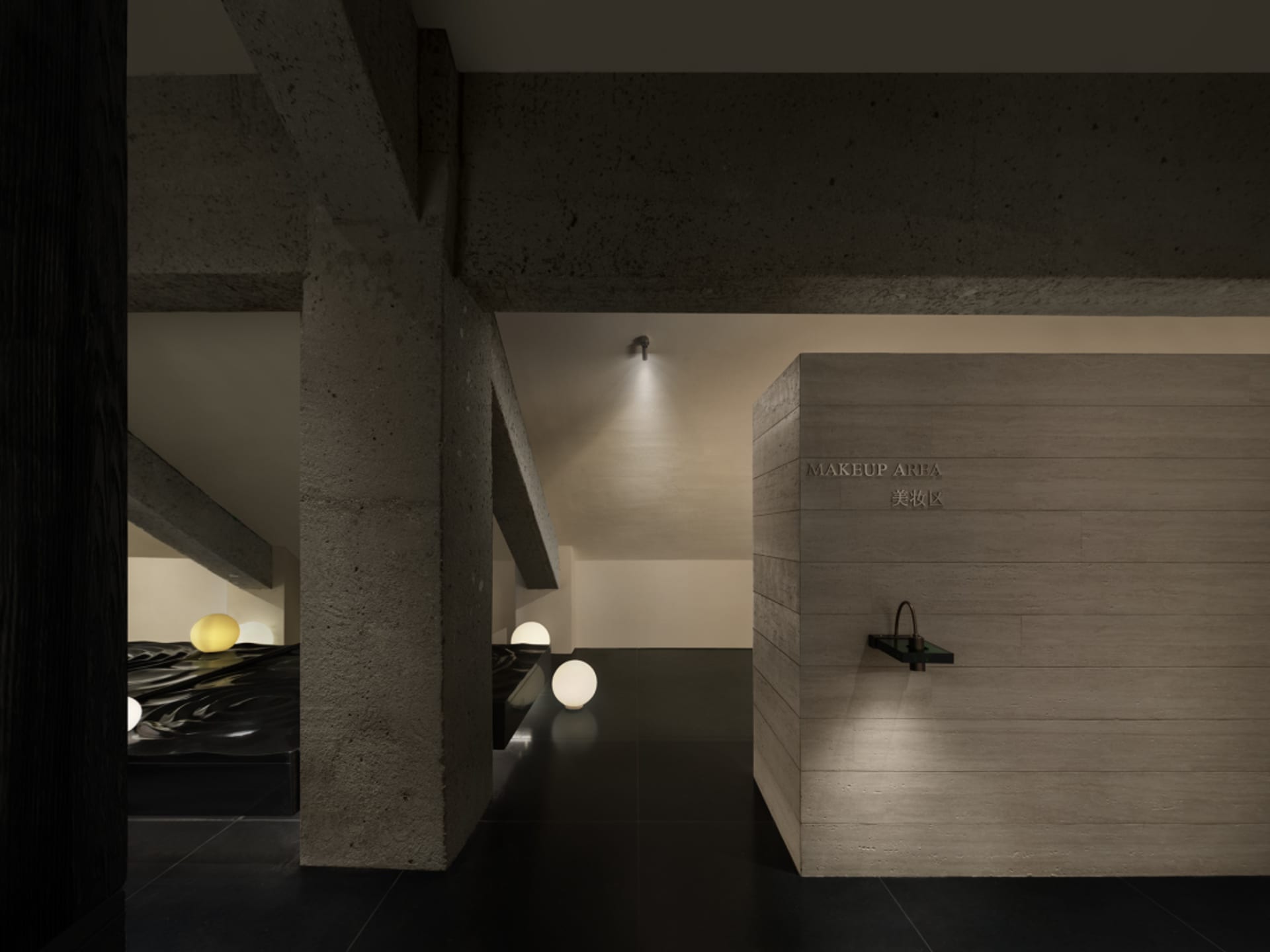 Dimly lit minimalist bathroom with a concrete wall, wooden door, and scattered small balls