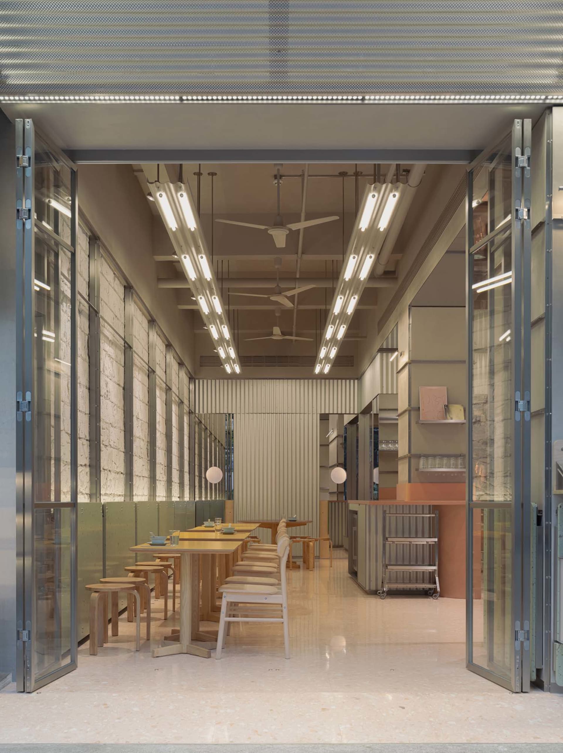現代餐廳空間內有多張木製餐桌椅，窗邊自然光線充足，营造明亮且溫馨的氛圍