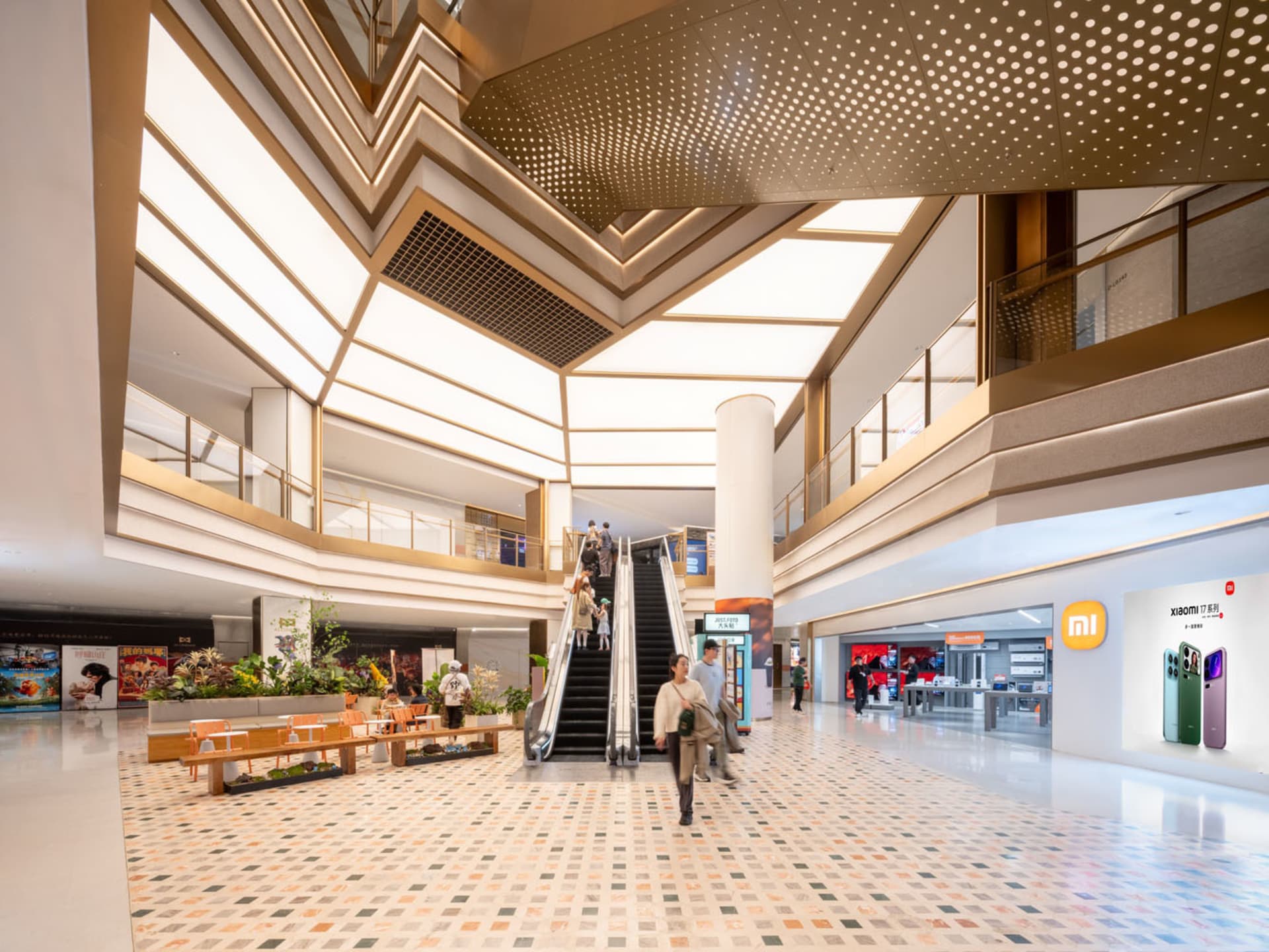 A large, open public space with a modern design, featuring a spiral staircase, benches, and a large atrium, with a warm and welcoming ambiance created by well-designed lighting