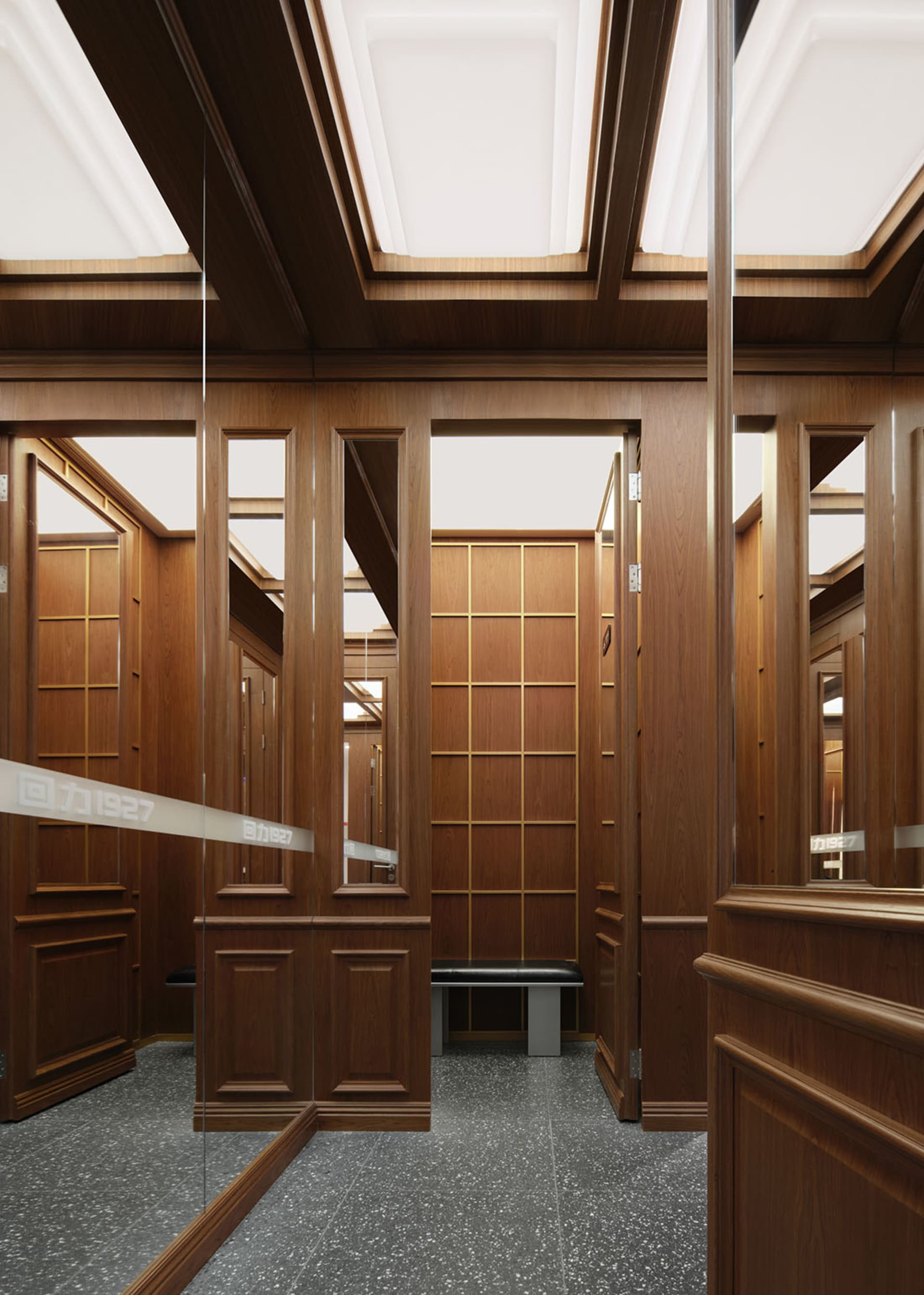 A dimly lit hallway with wooden walls and doors, lined with mirrors to create an illusion of depth