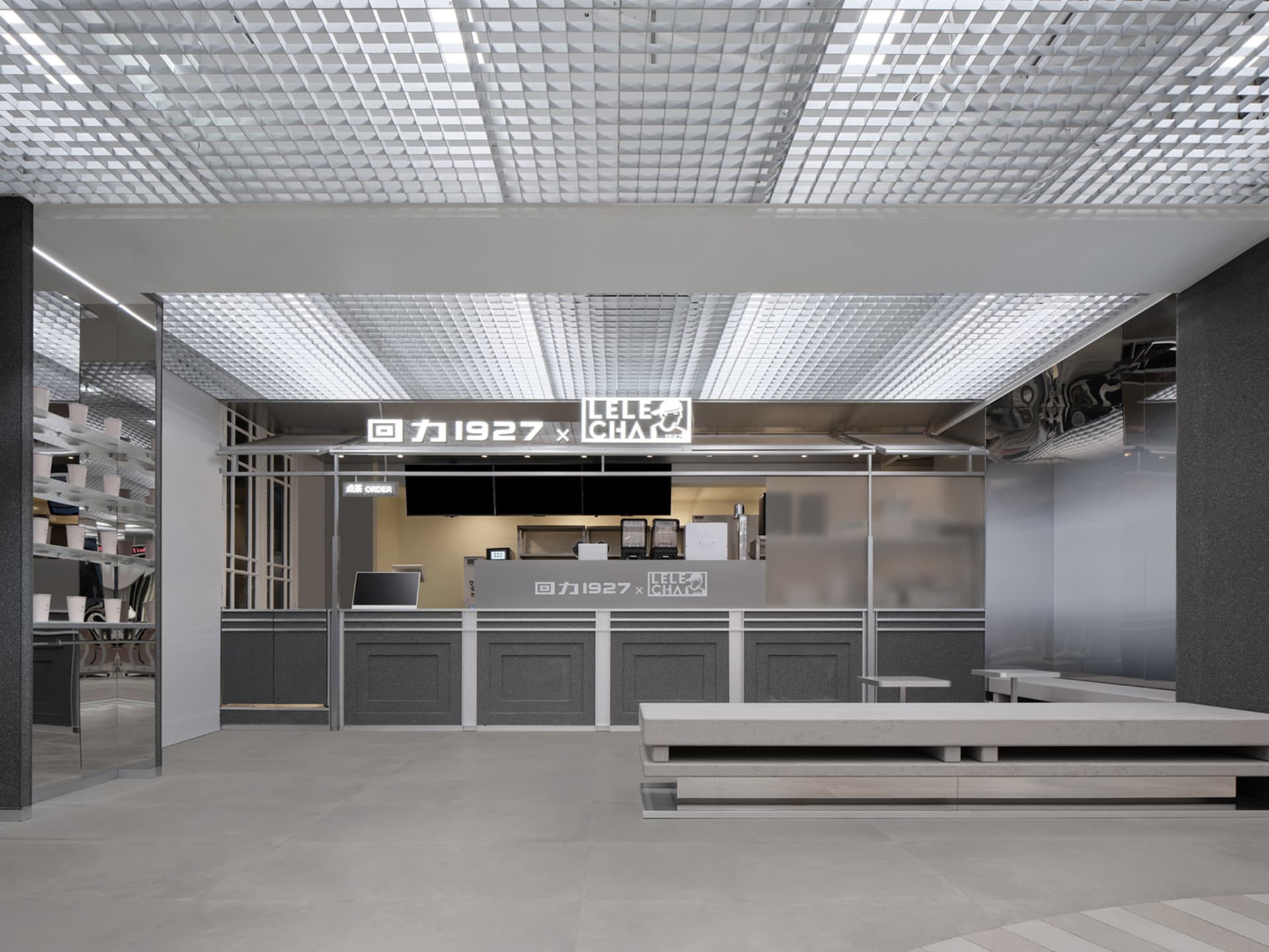現代餐廳內景，寬敞用餐區設有多張長椅與吧台，燈光充足，營造溫馨迎賓氛圍