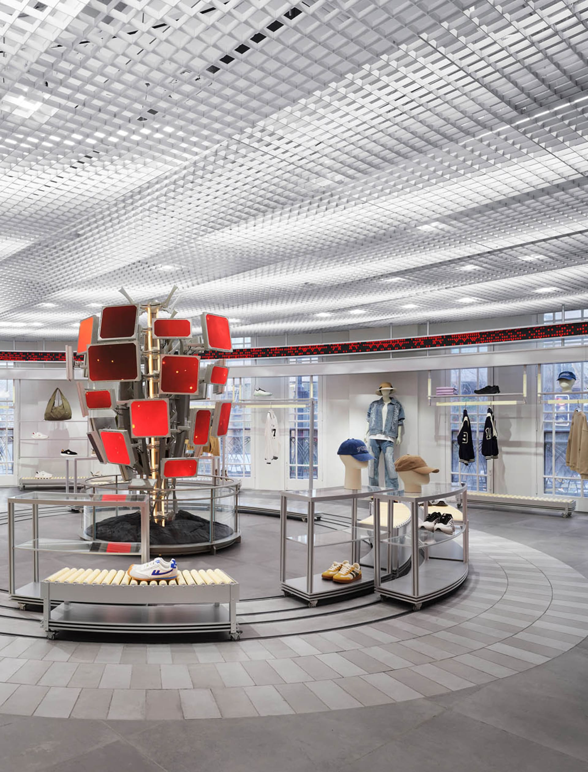 A modern store with a circular display surrounded by shelves and tables, showcasing a variety of items in a bright and inviting atmosphere