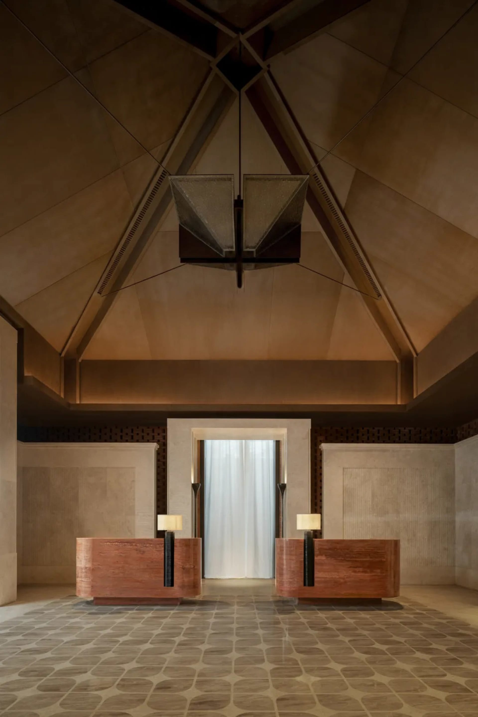A modern lobby with wooden benches and a stone ceiling, featuring a light fixture and a clean, minimalist design
