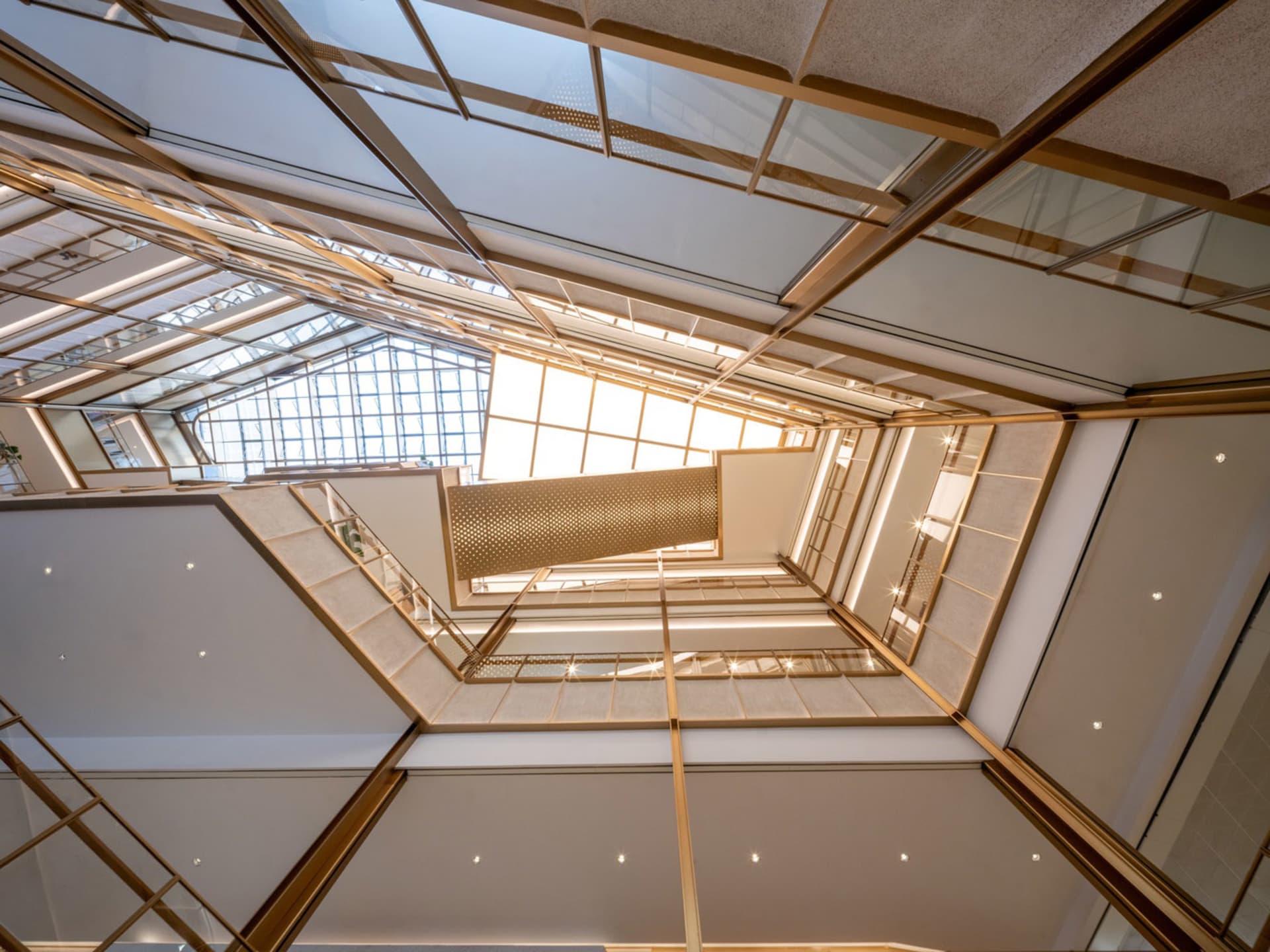 A bright and airy interior space with a large atrium, glass ceiling, and modern design