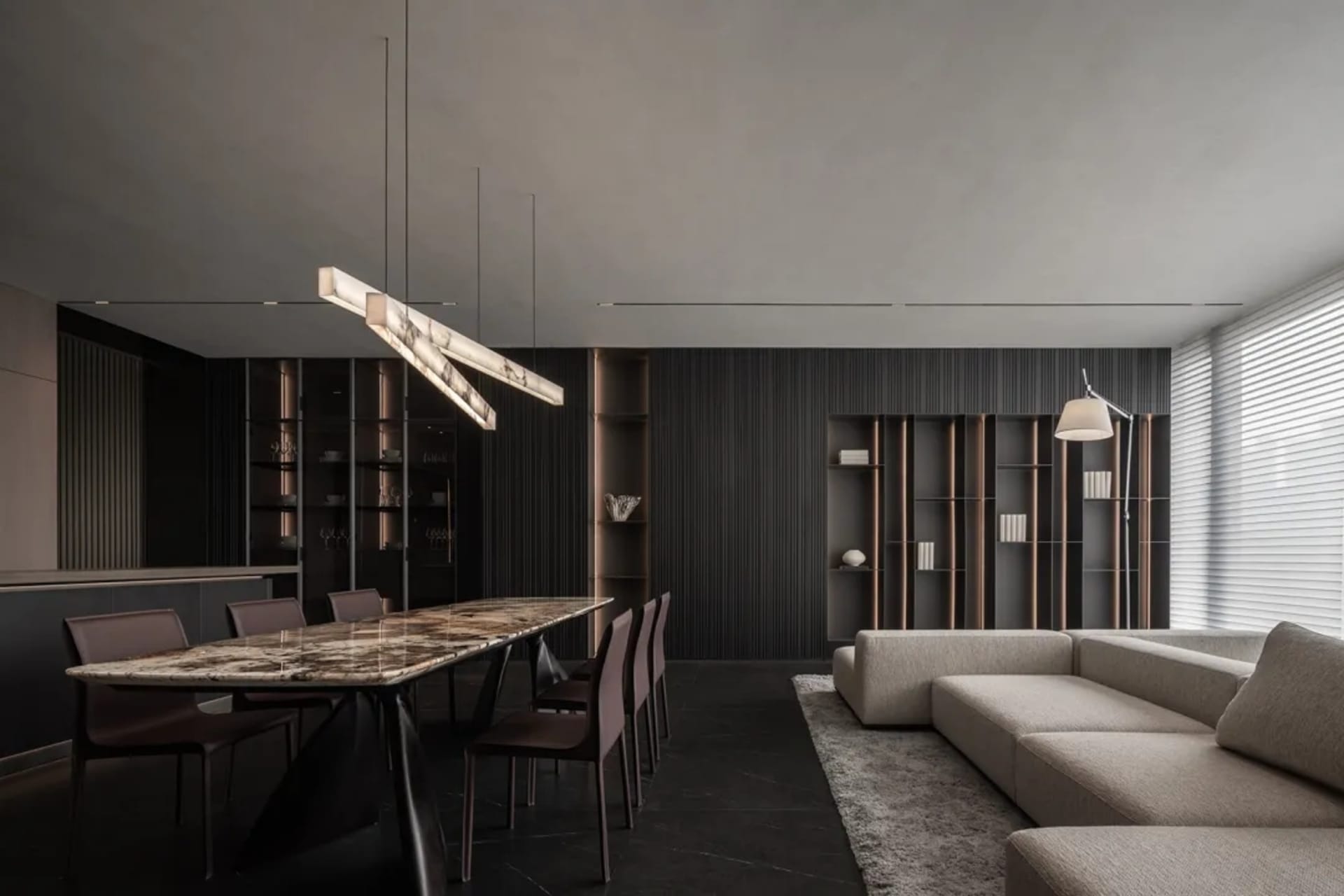 A modern living and dining space with a wooden theme, featuring a couch, chair, dining table, and chairs, with dim lighting creating a cozy ambiance