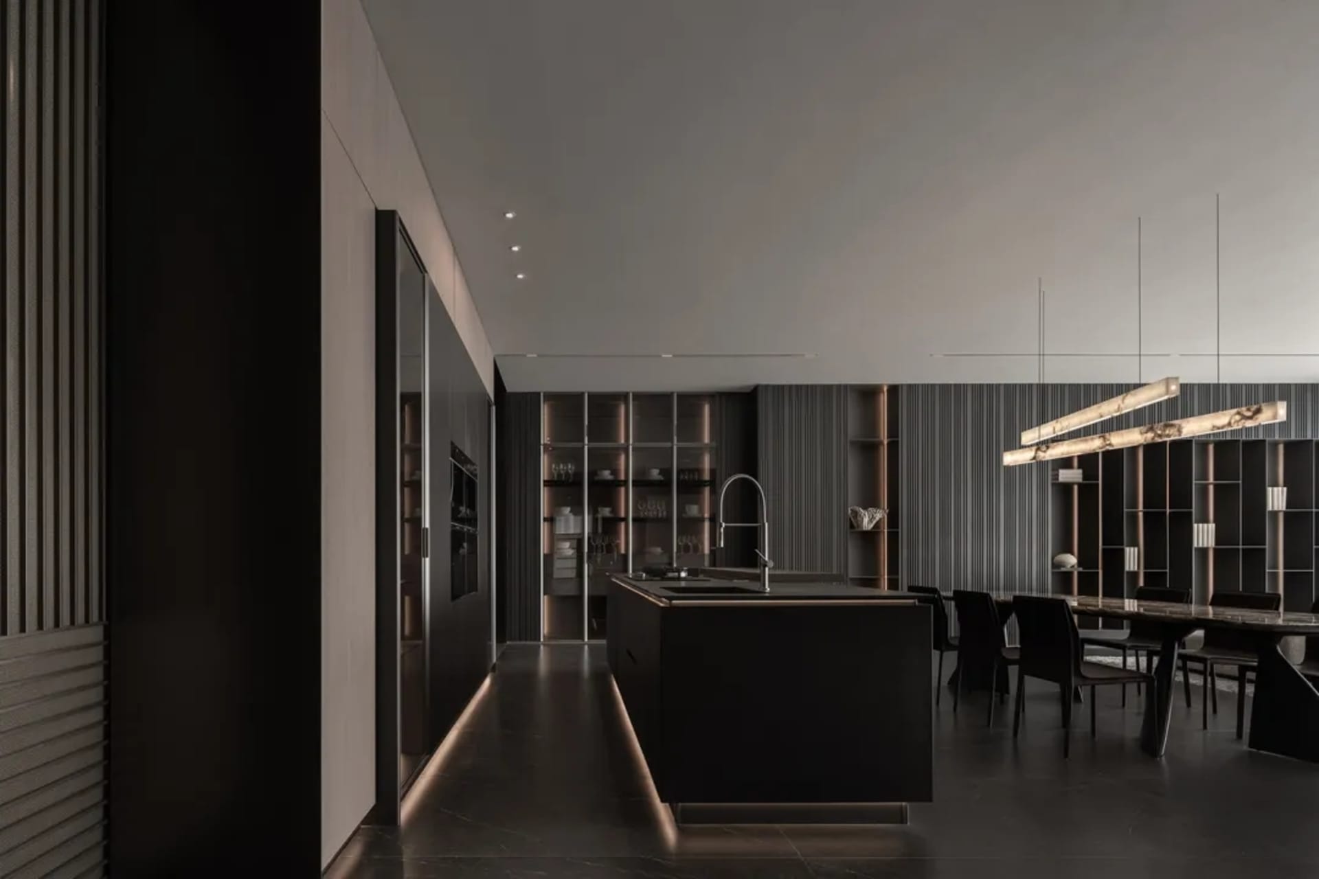 Modern kitchen and dining space with a black countertop, dining table, and natural light