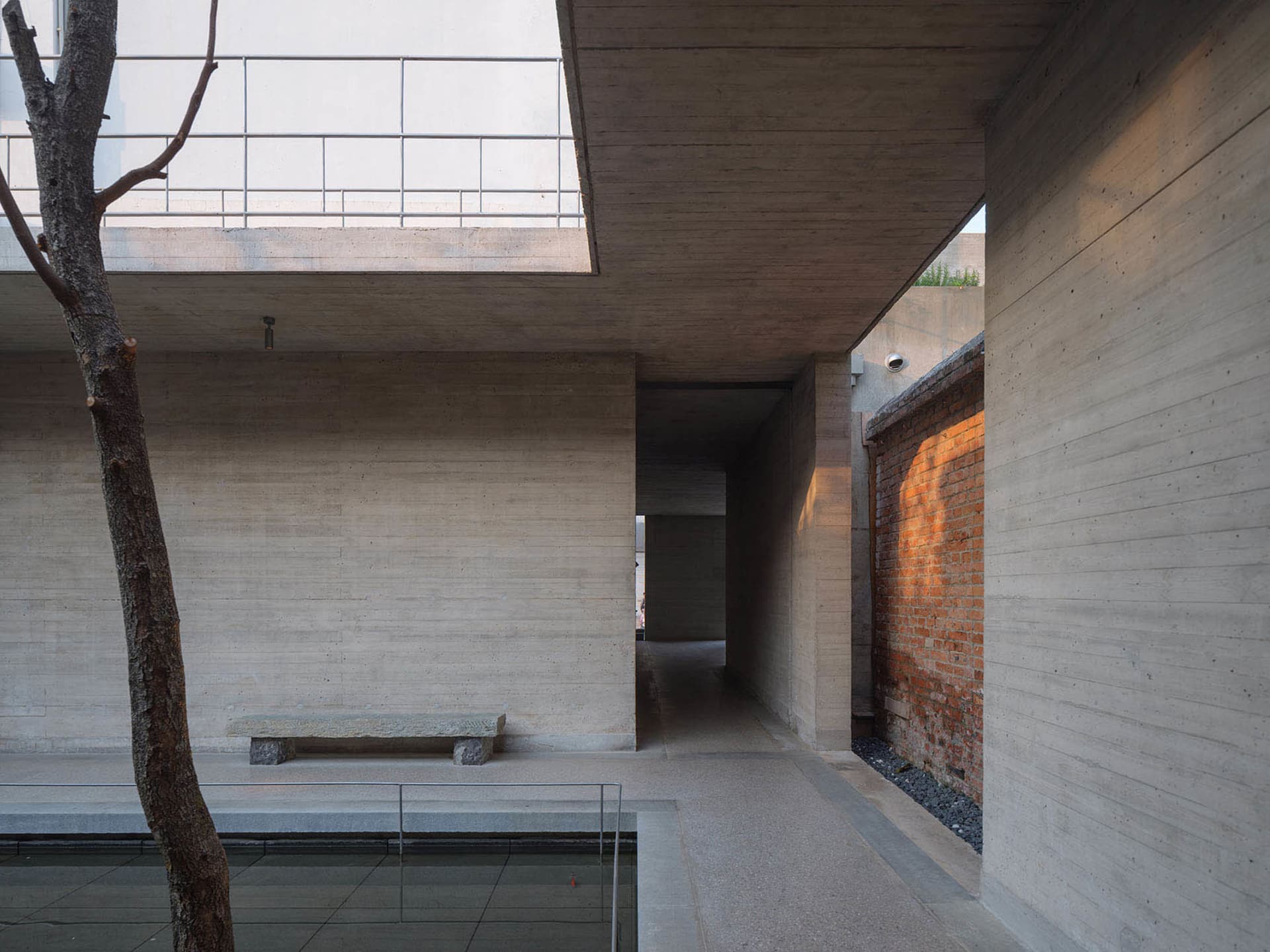 Large modern building with a concrete facade, open space, high ceiling, and natural light