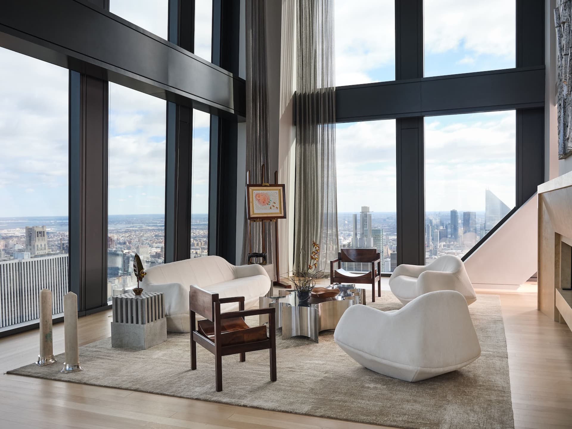 A well-lit living room with a large window, modern furniture, and decorative items, showcasing a beautiful city view