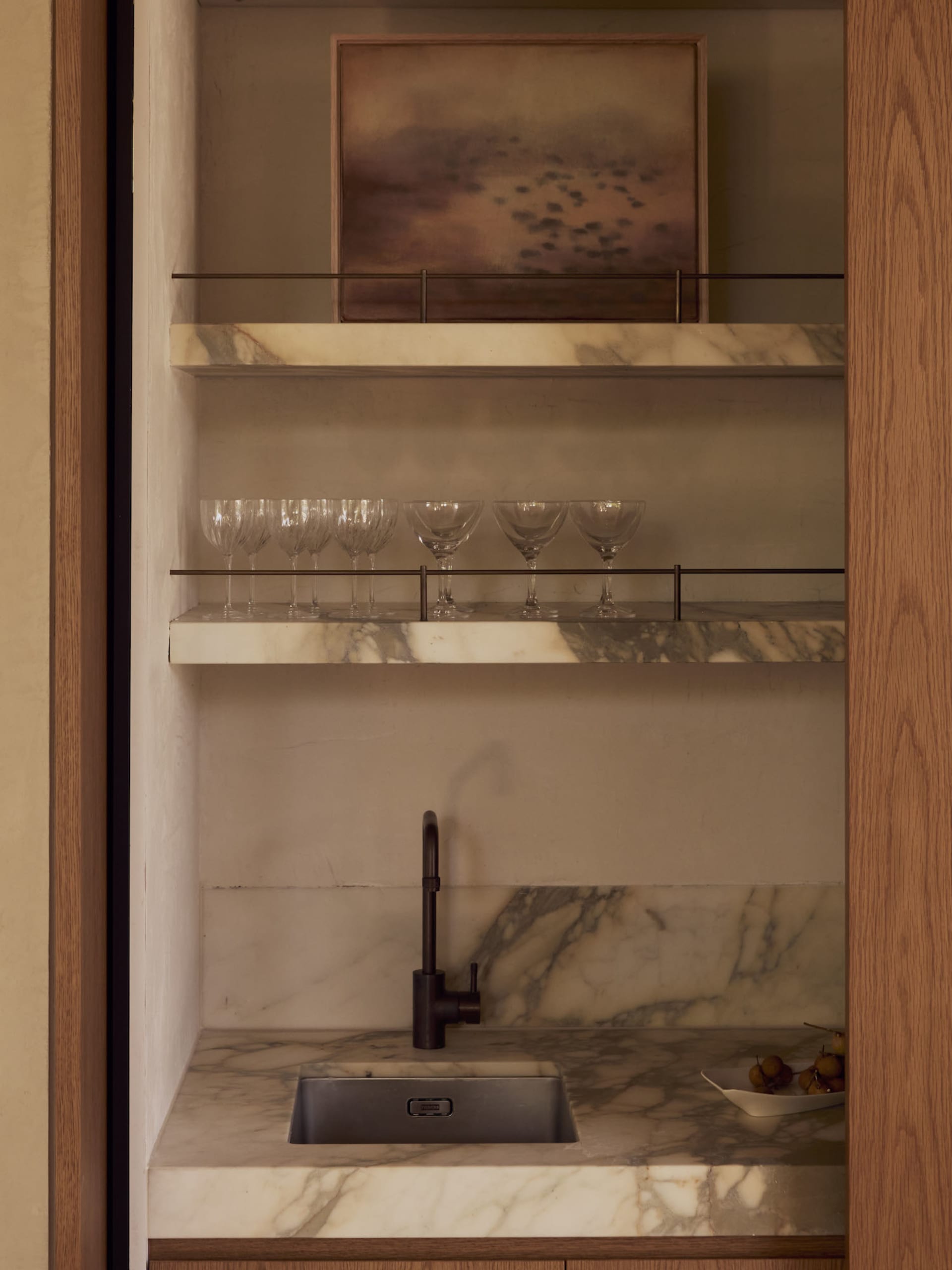 Modern kitchen with a marble countertop, metal sink, and natural light from the windows