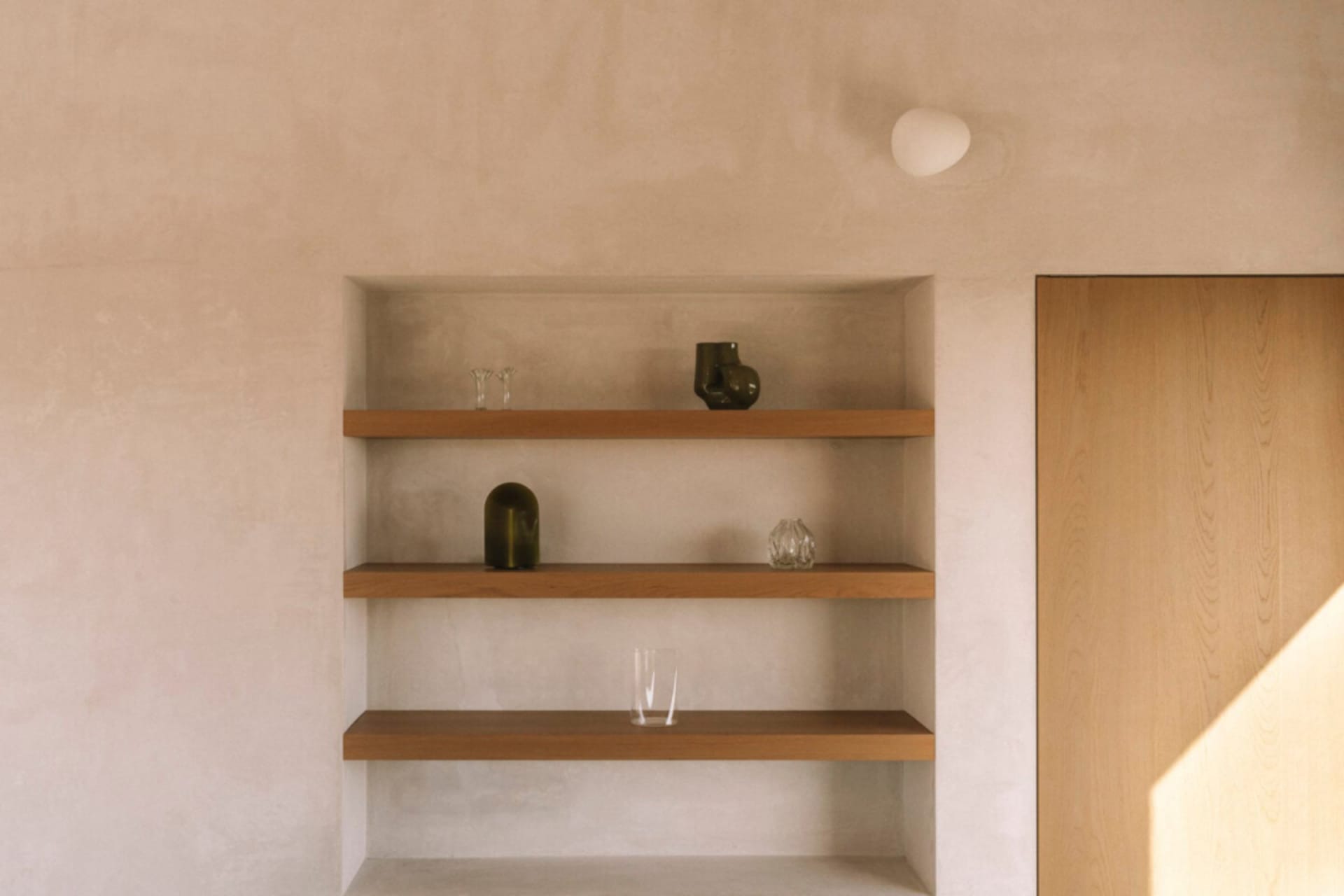 Cozy living space with a wooden bookshelf, natural light, and various decorative items