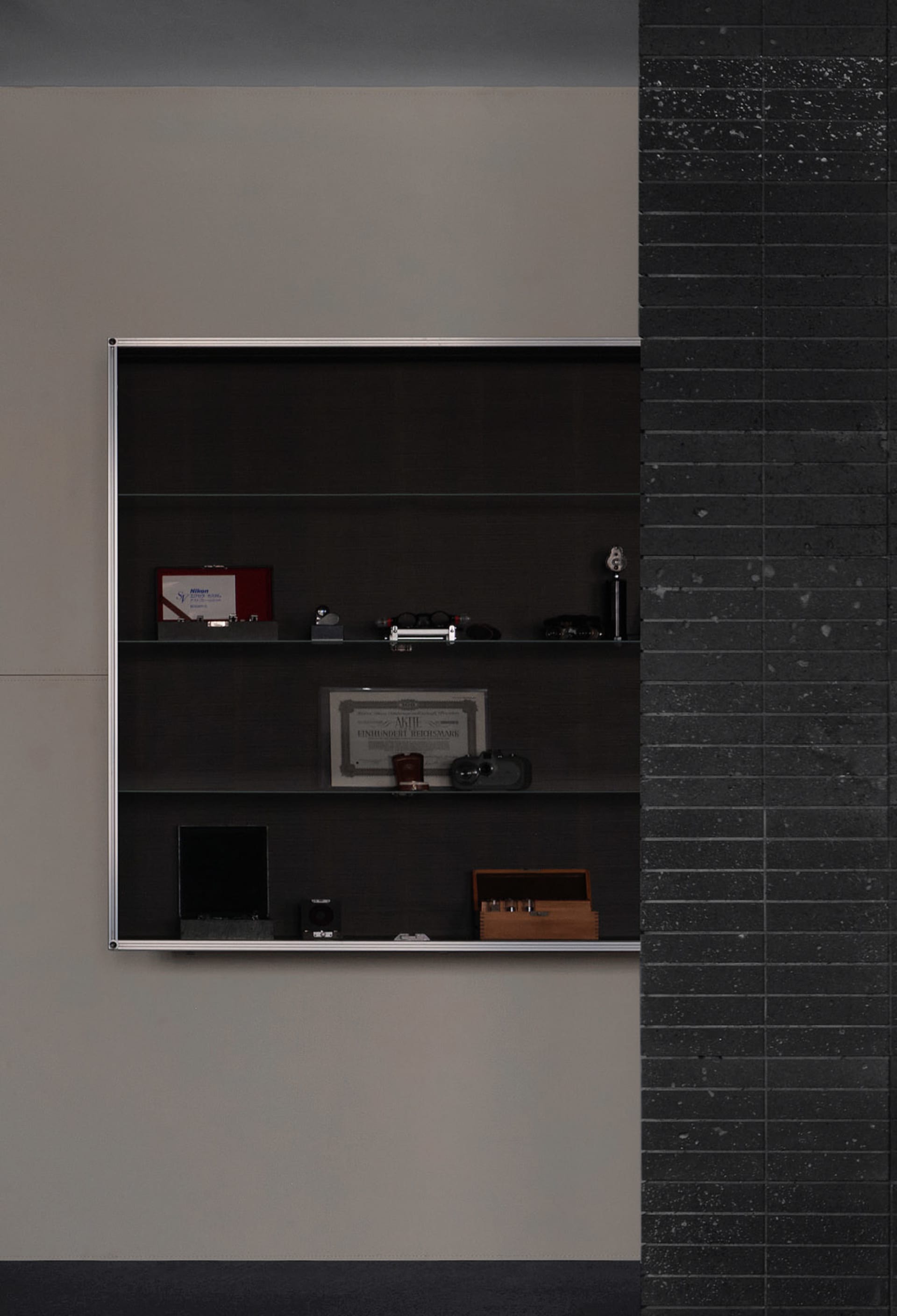 A study or living area with a black and white color scheme, featuring a wooden bookshelf with books and a clock, and a focus on organization and functionality