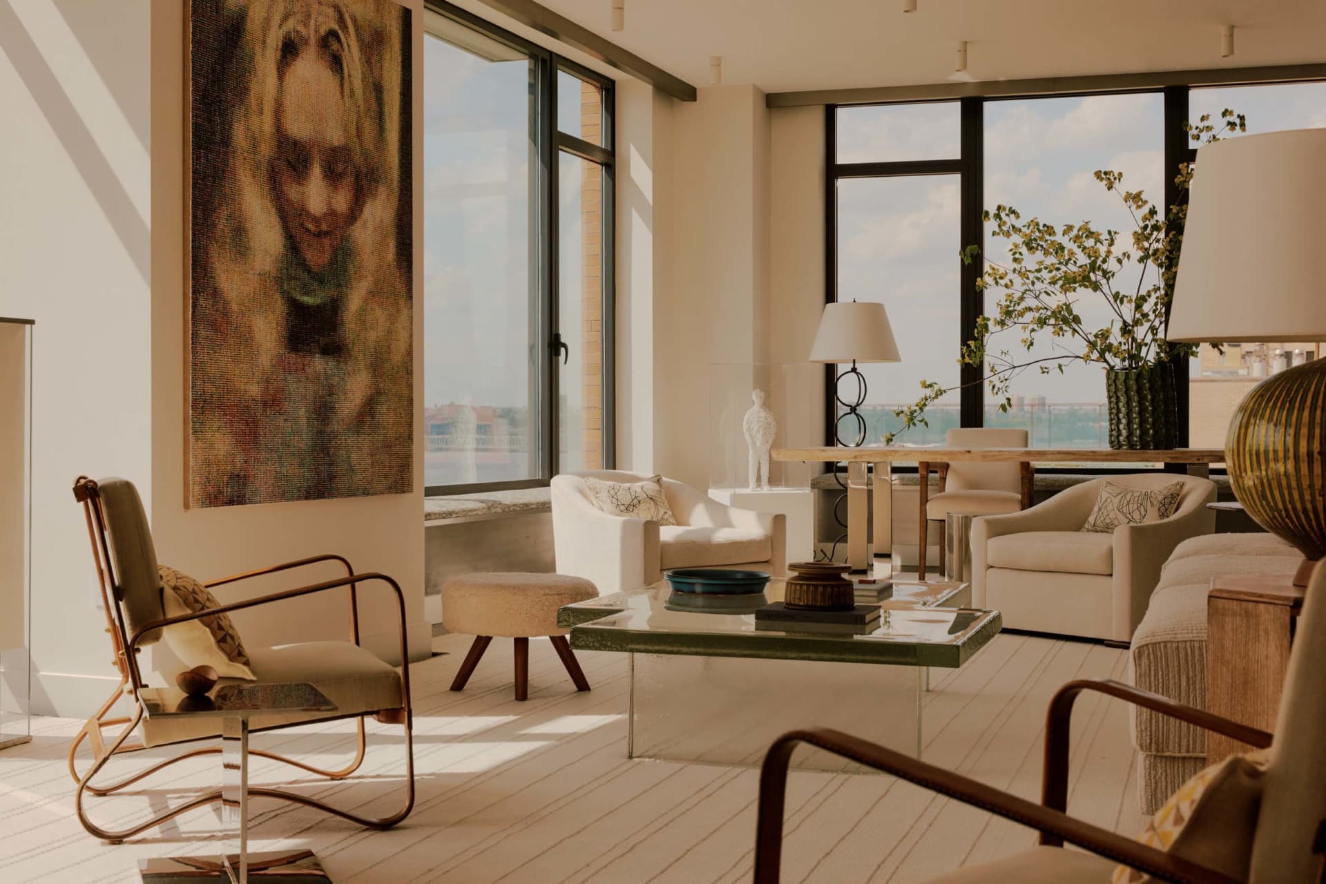 A well-lit and spacious living room with modern furniture, a large window, and natural decor
