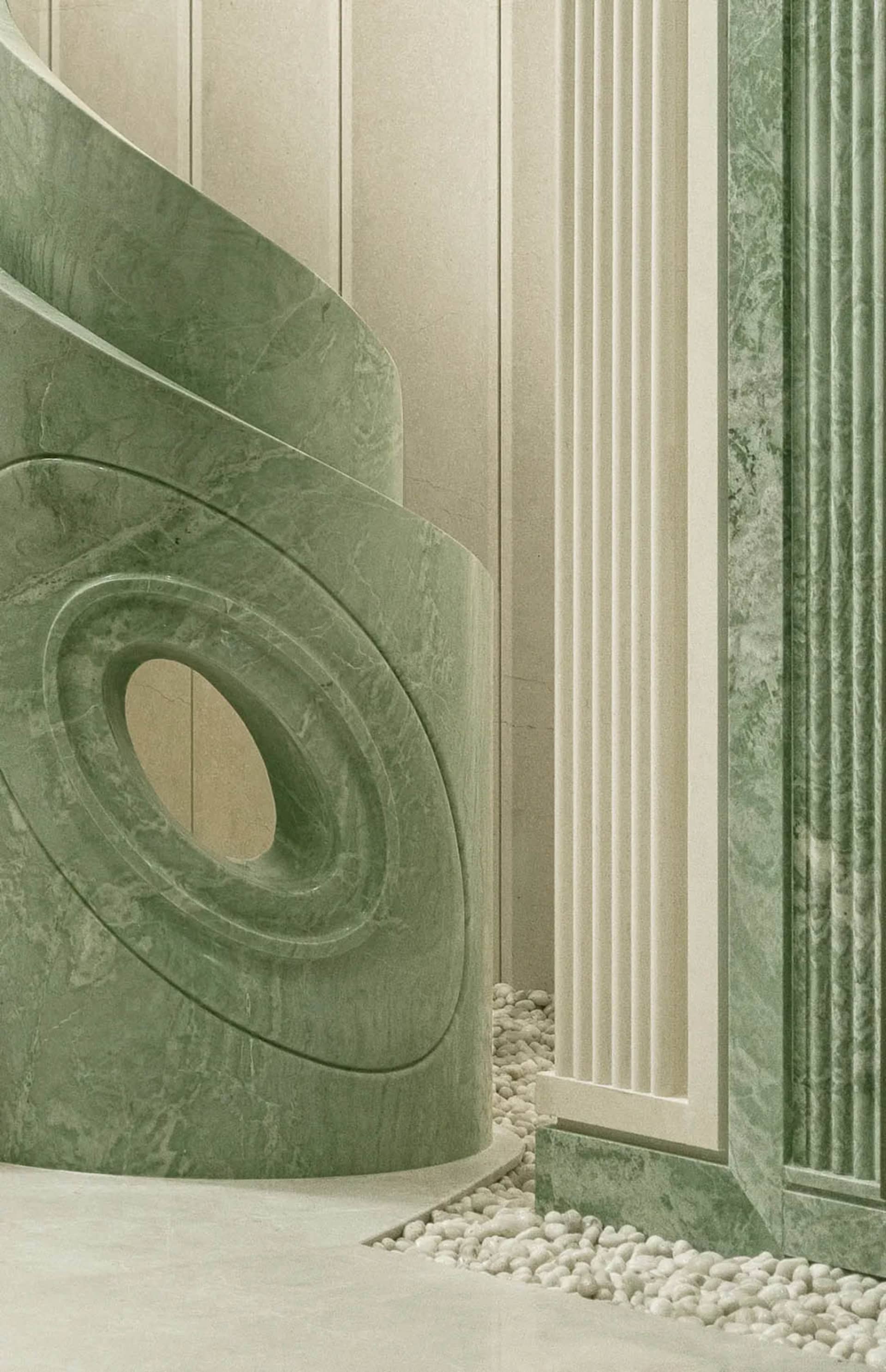 Modern building with a large circular sculpture and green marble-like walls, set in a soft and diffused light