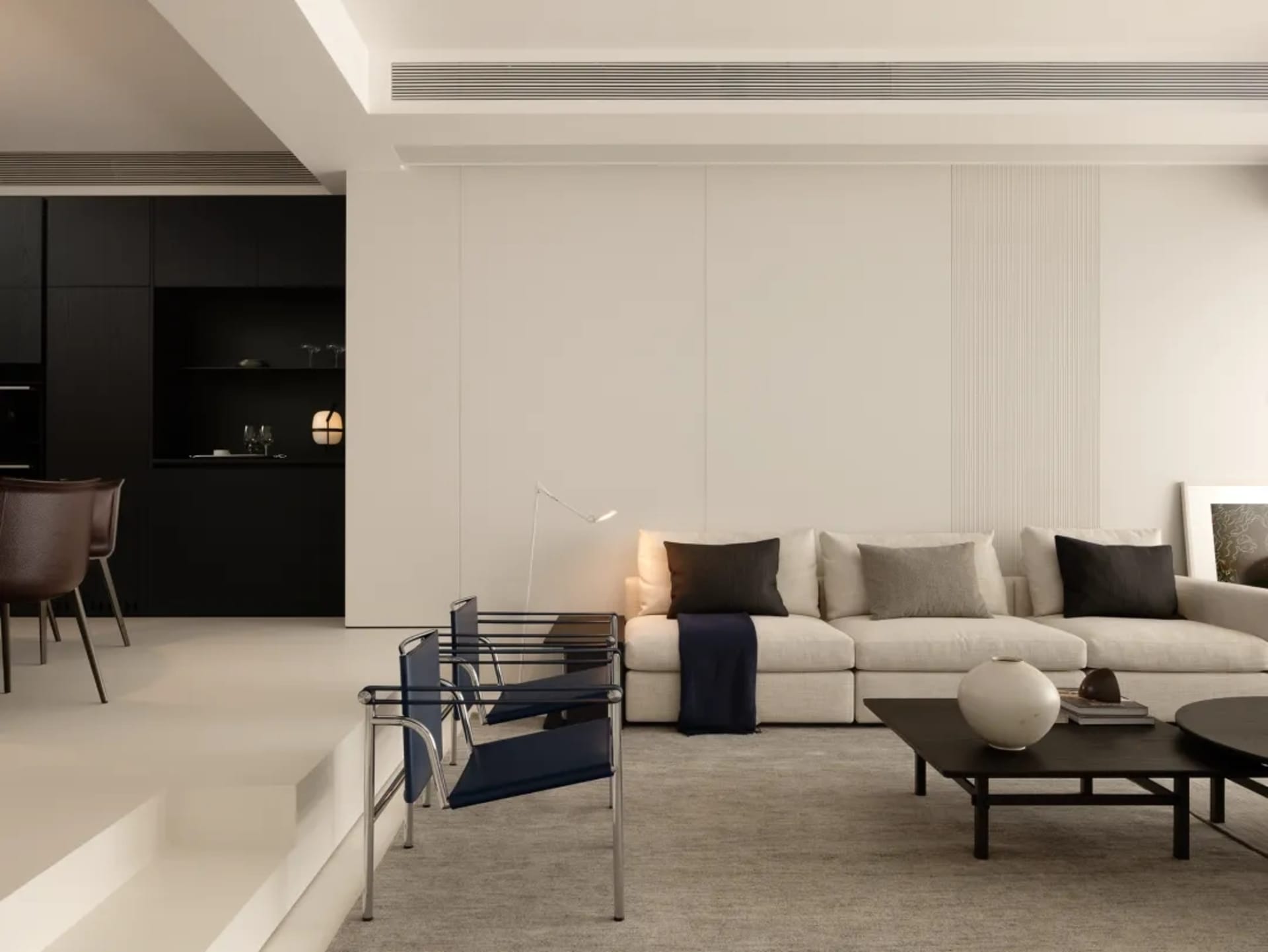 A modern living room with a white couch, chair, and dining table, surrounded by various decorative items and well-lit for a cozy atmosphere