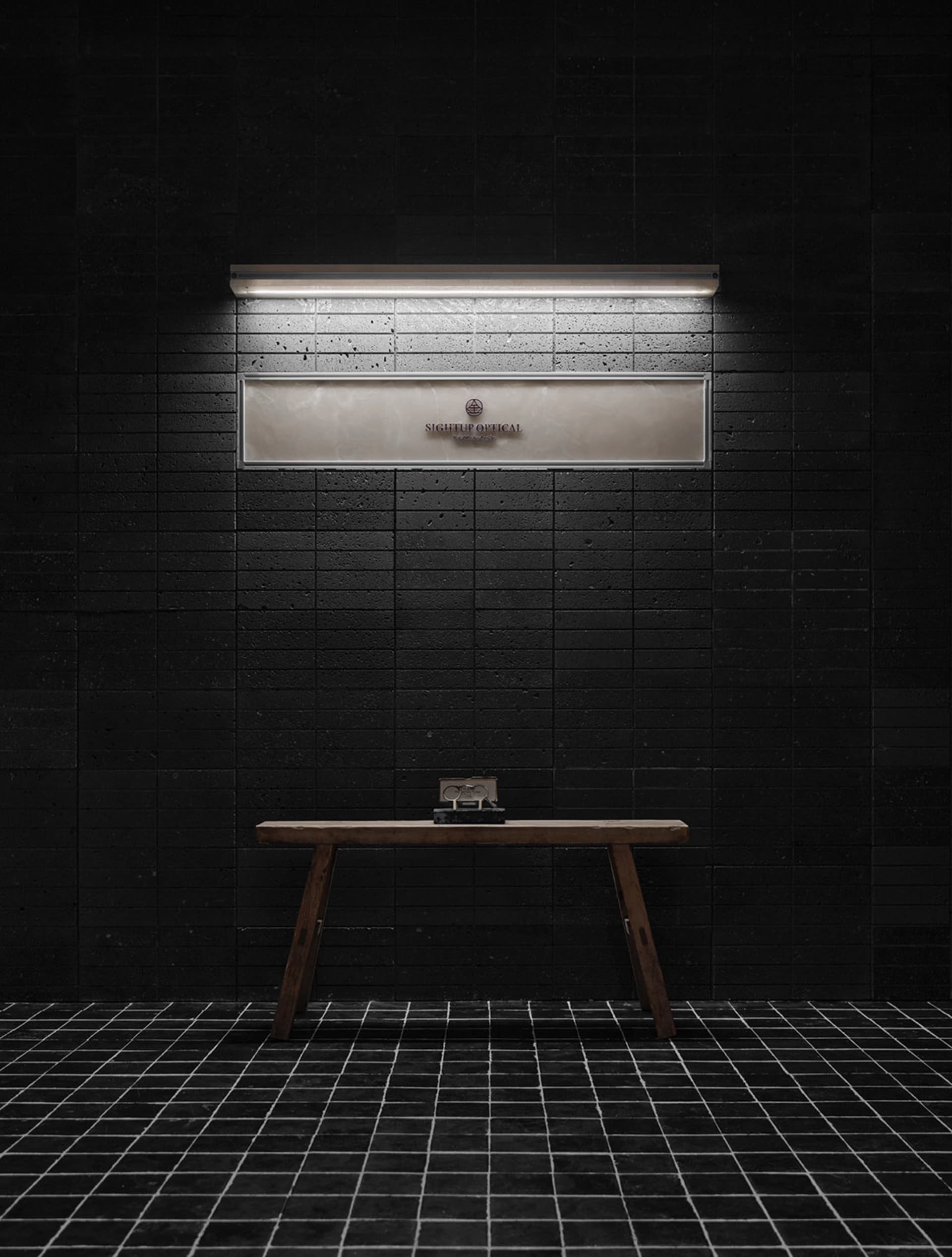 A dimly lit bathroom with a wooden bench and a mirror above it, set against a black tile floor