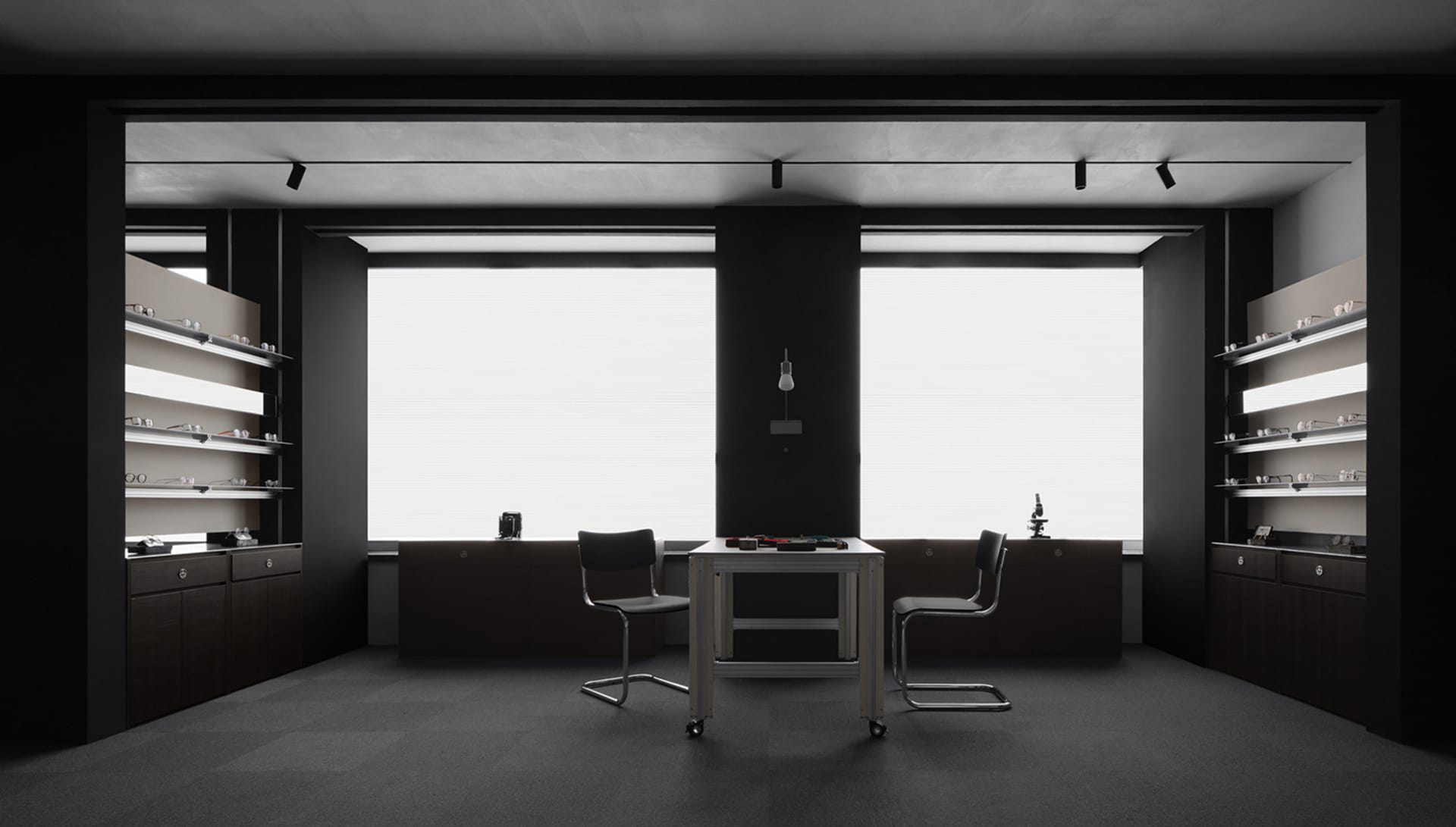 A modern office space with a black table and chairs, dimly lit, creating a moody atmosphere