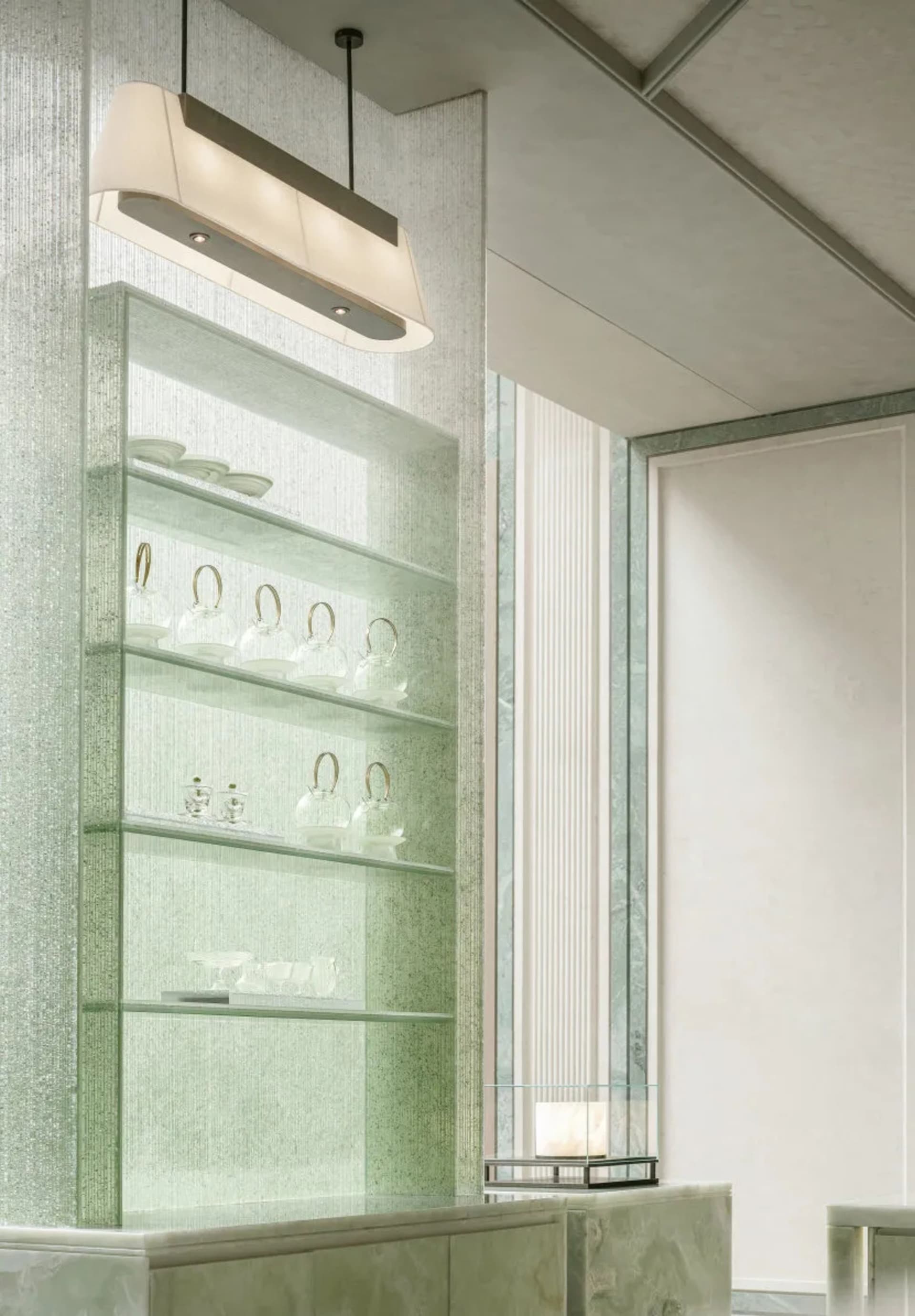 A well-organized bathroom with a green glass shelf holding various cups and bowls, creating a functional and tidy space