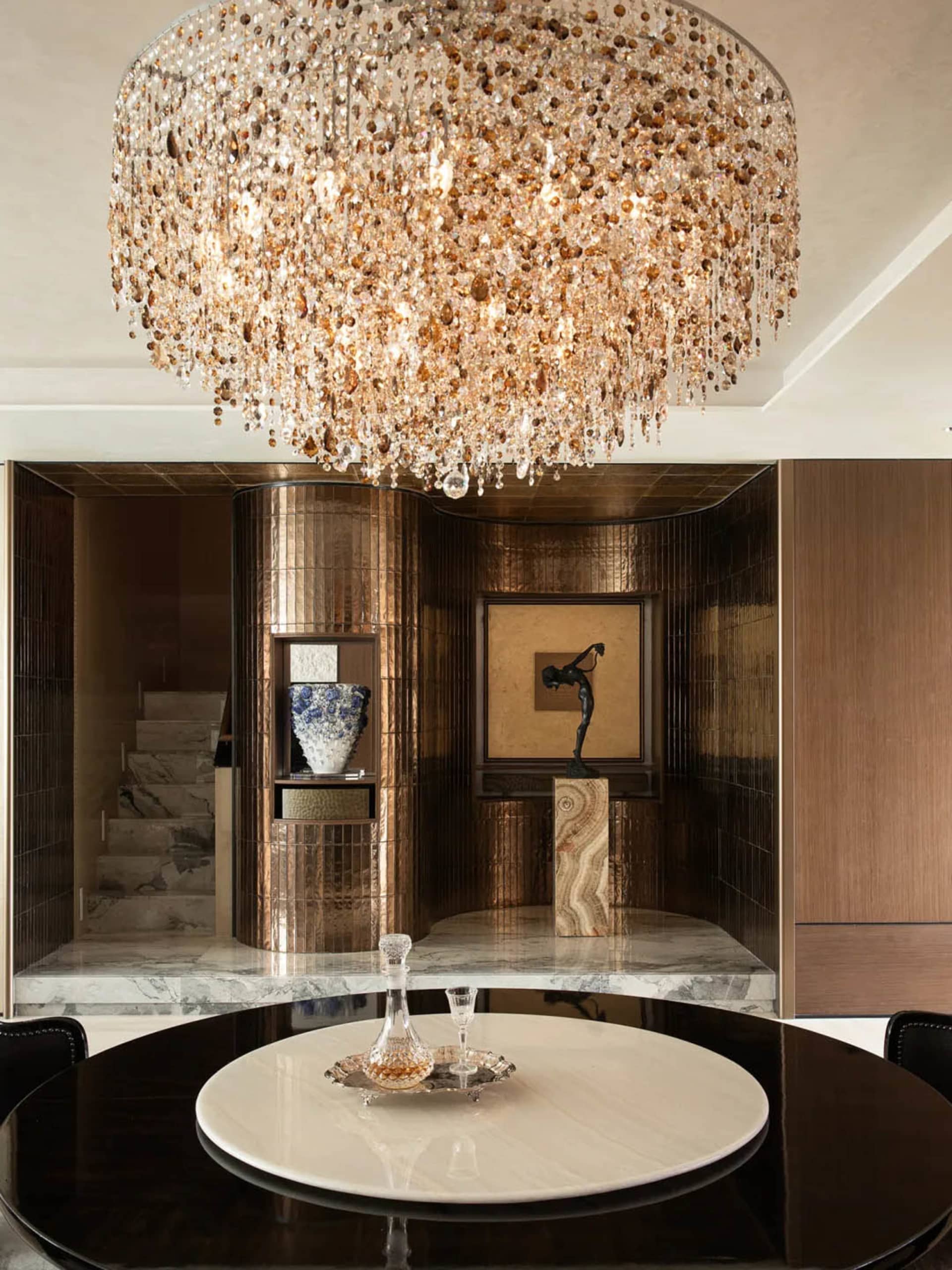 Dining room with a glass chandelier, a dining table, and various decorative items, set in a well-lit space with natural light from a window