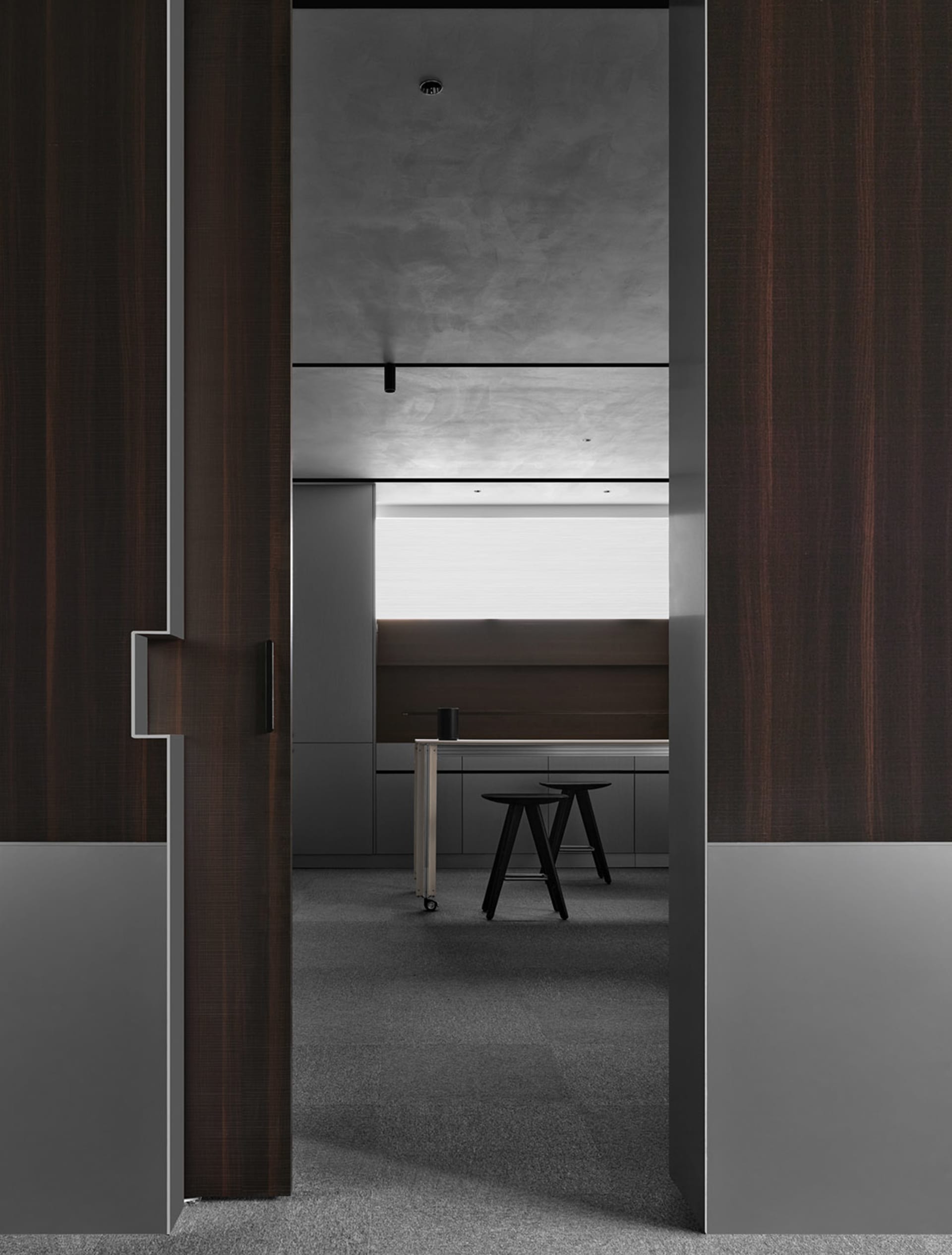 Small office space with a wooden door, a desk, and a chair, set against a simple background
