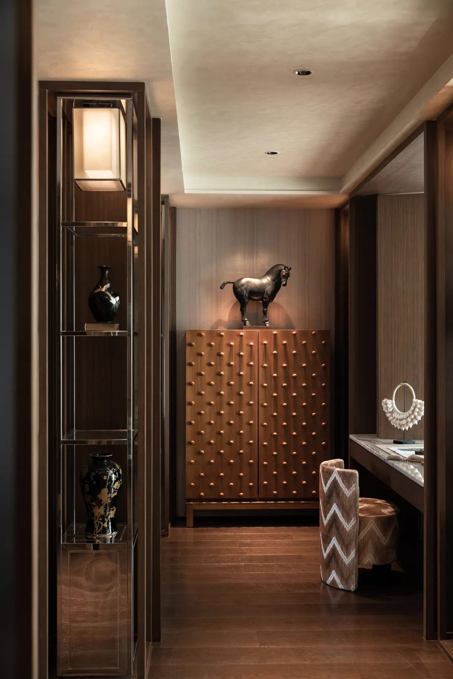 Cozy hallway with a brown color scheme, wooden floor, and decorative vases, lit with dim lighting