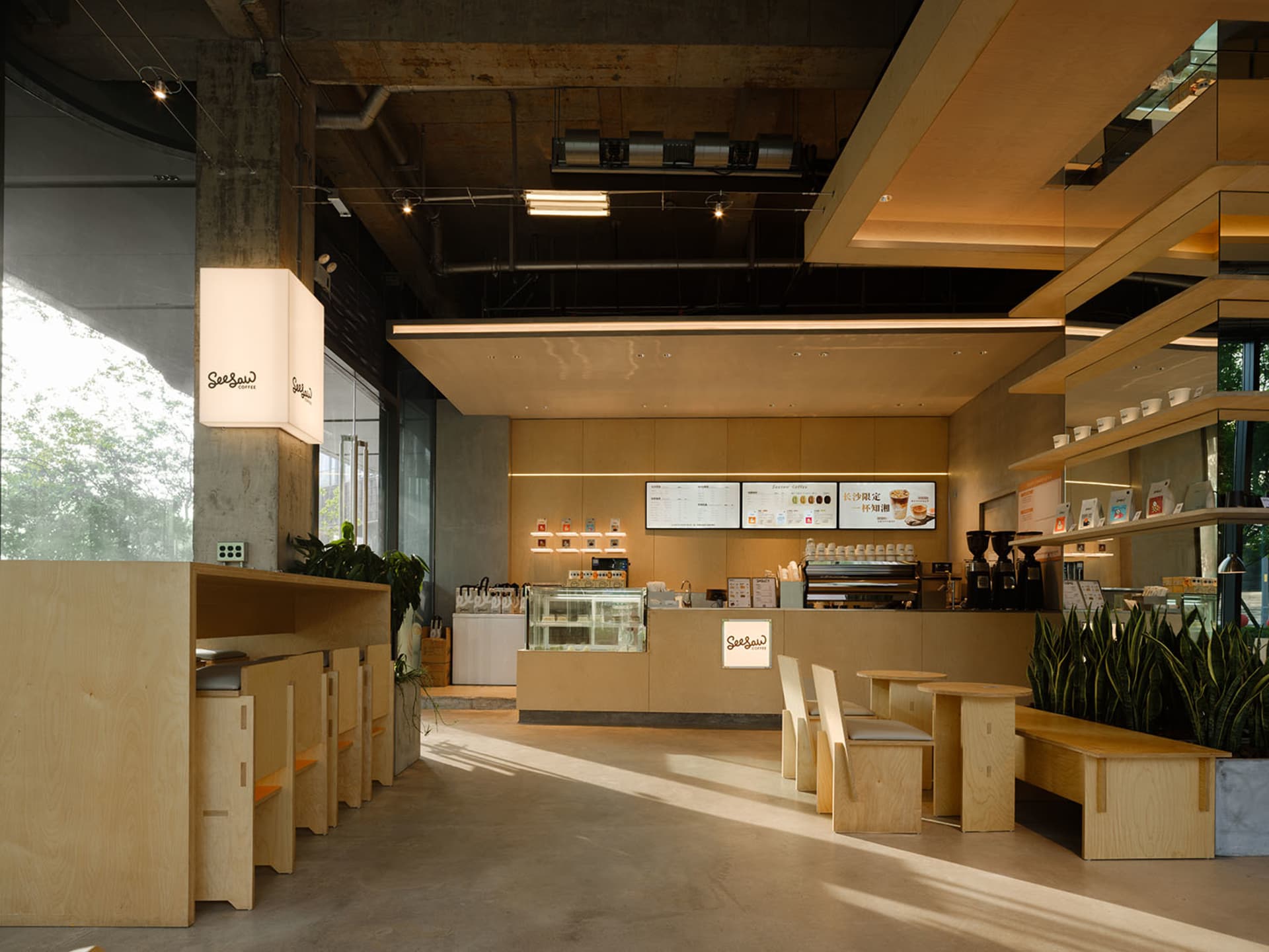 A modern coffee shop with a clean and minimalist aesthetic, featuring a large open area with wood furniture and a predominantly white color scheme, soft and warm lighting, and a welcoming atmosphere