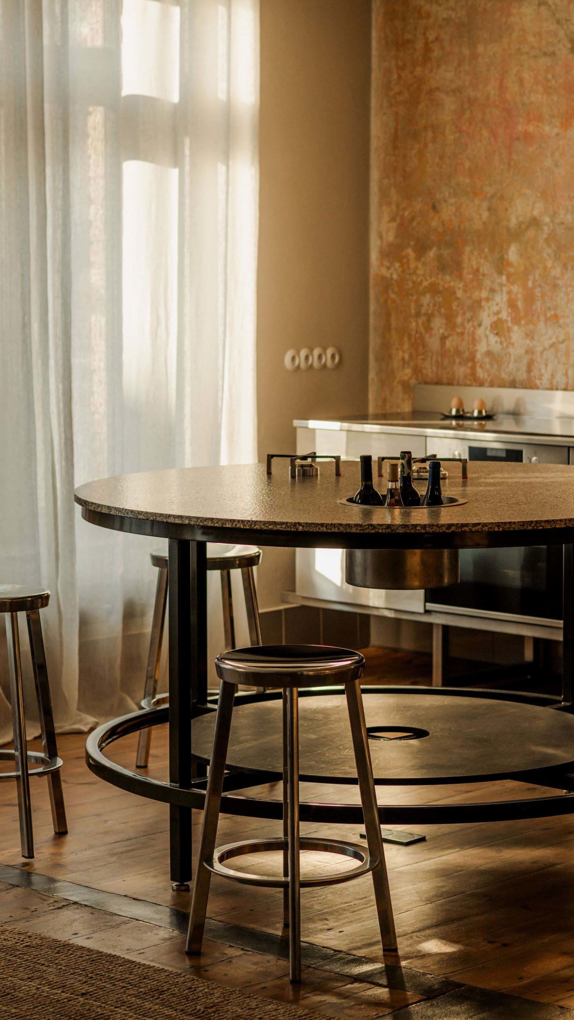 A residential kitchen with a dining table and chairs, black and white color scheme, and natural light creating a bright and clean atmosphere