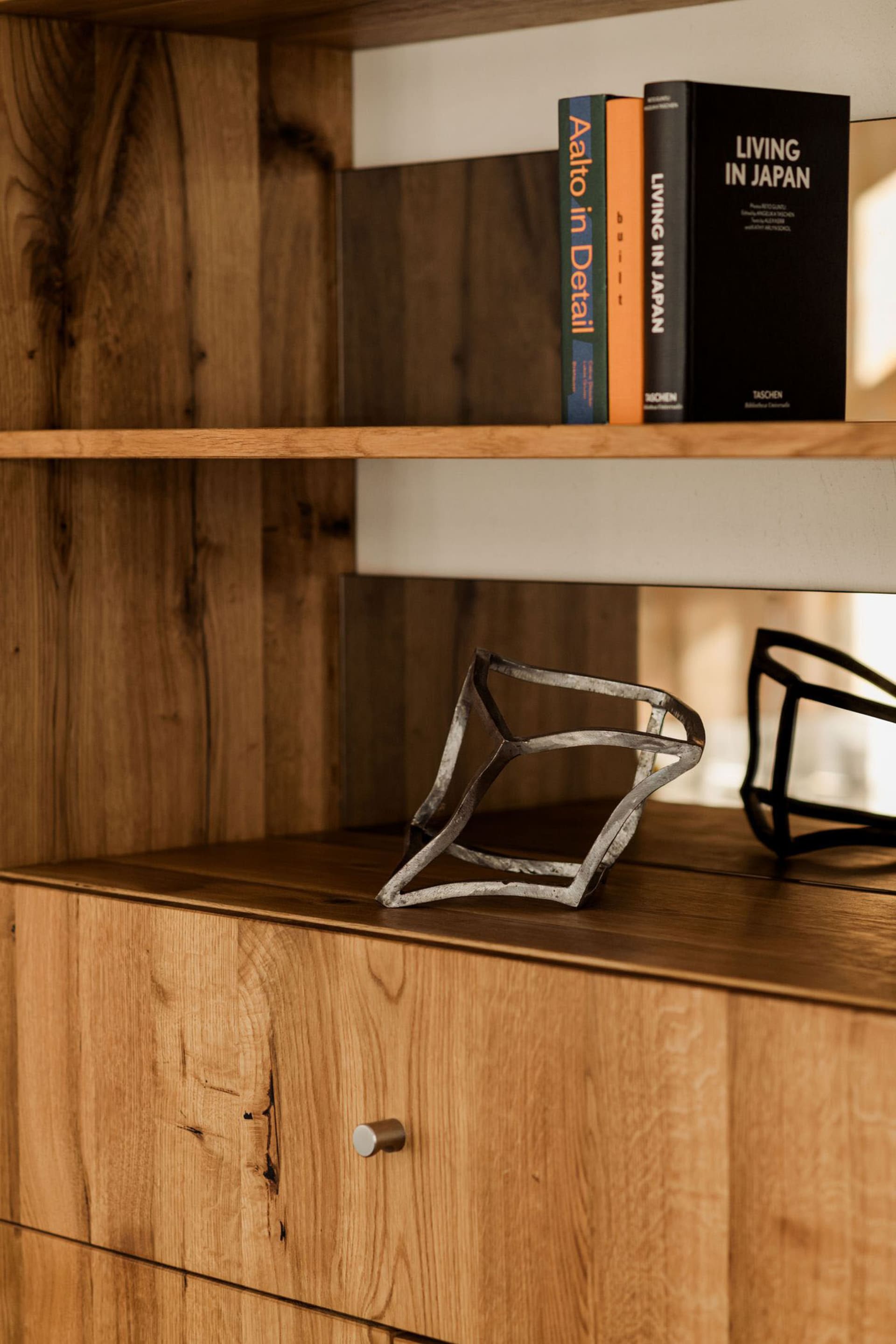 A wooden bookshelf with various books arranged in a visually interesting scene, lit by natural sunlight, creating a cozy and inviting atmosphere