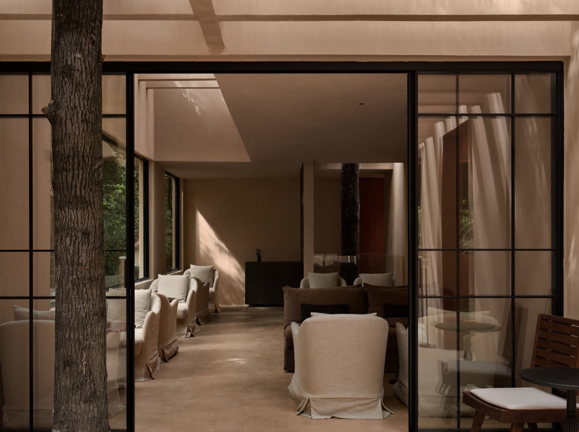 Comfortable living space with a mix of natural and artificial lighting, featuring a variety of furniture and materials, including wood, fabric, and metal, in a modern and contemporary style