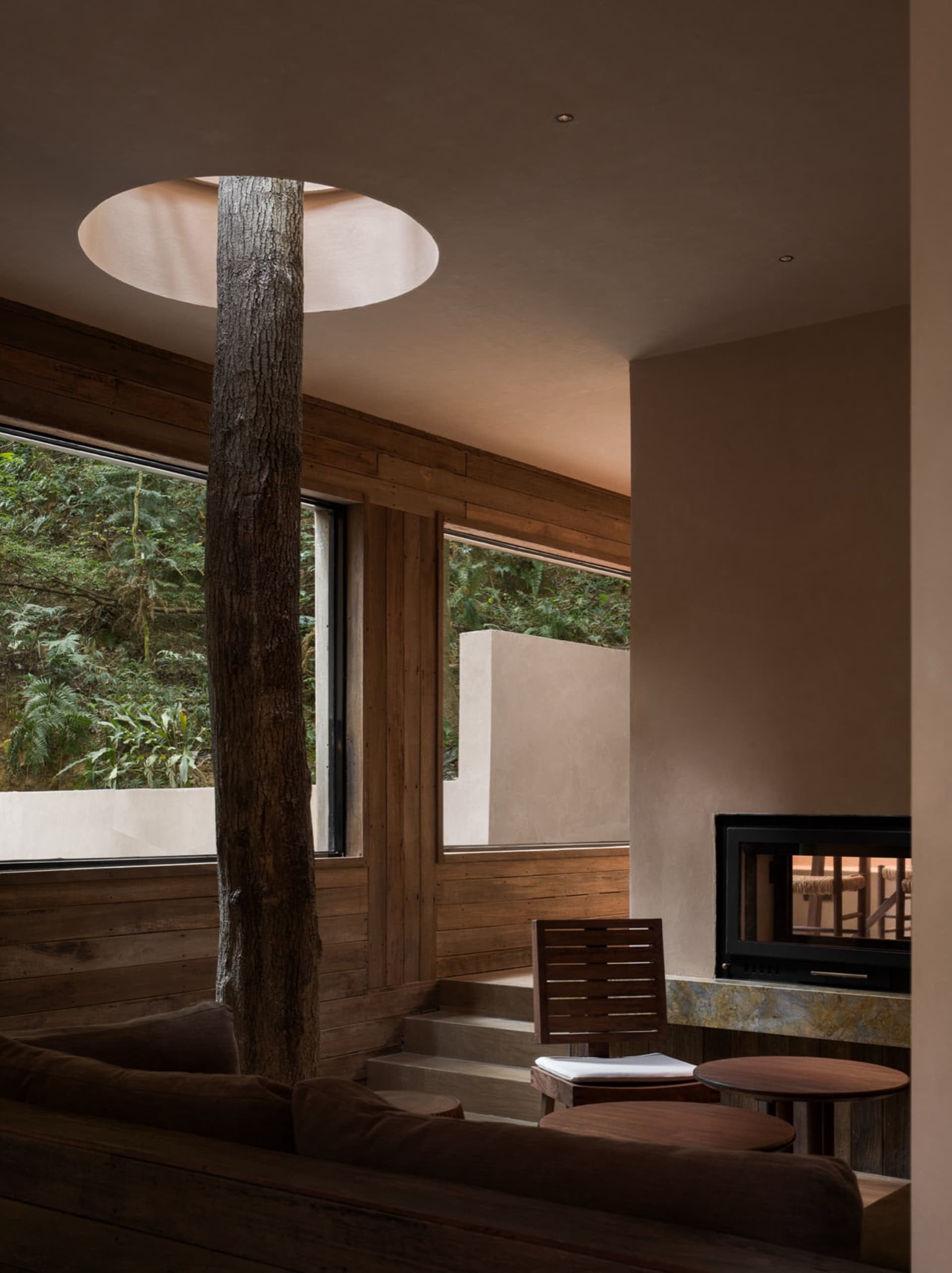 Cozy living room with a stone fireplace, a couch, a chair, and a dining table, creating a warm and inviting space for relaxation and socializing