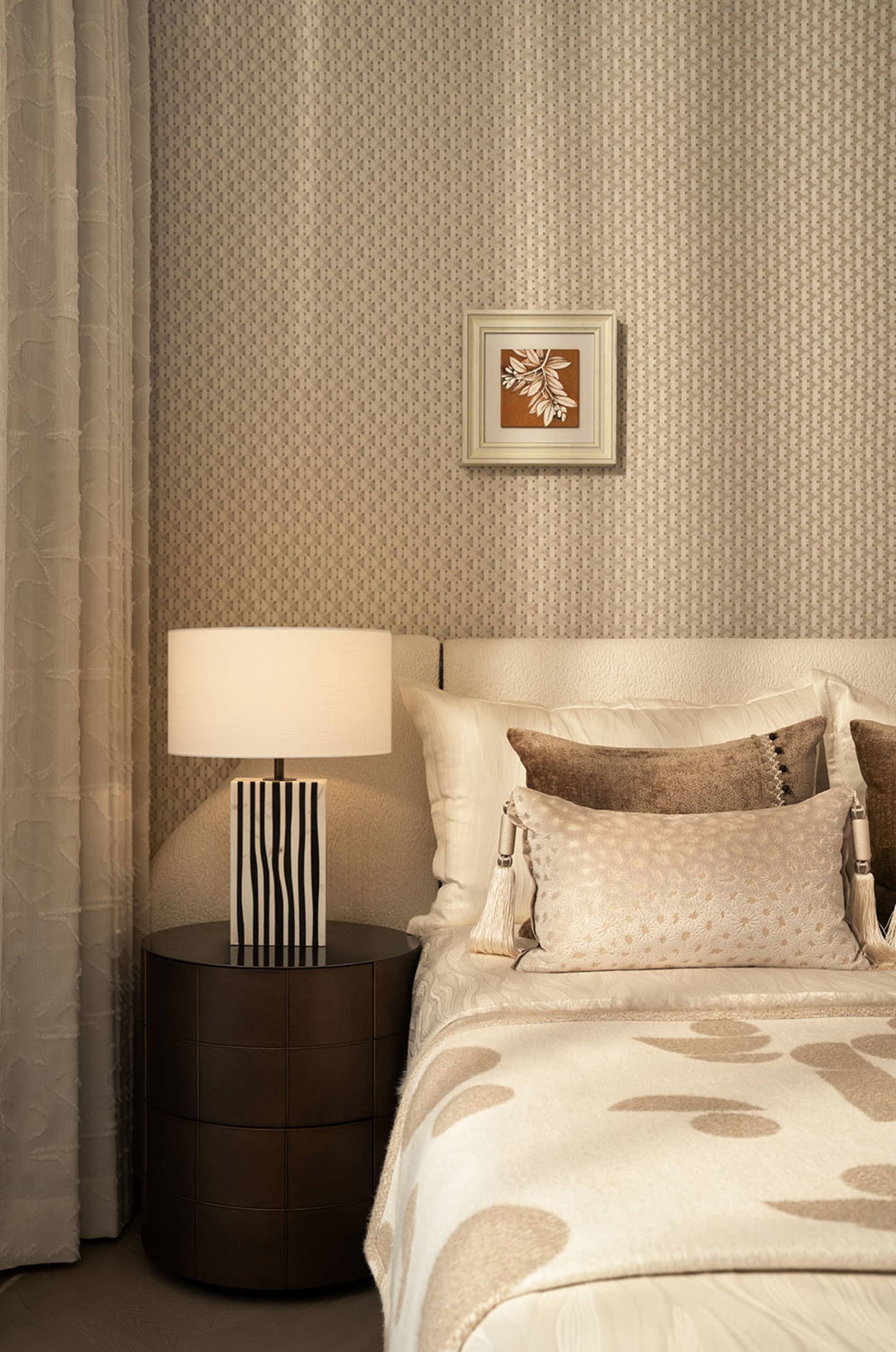 Cozy bedroom with a white comforter, a bedside lamp, and a framed artwork on the wall