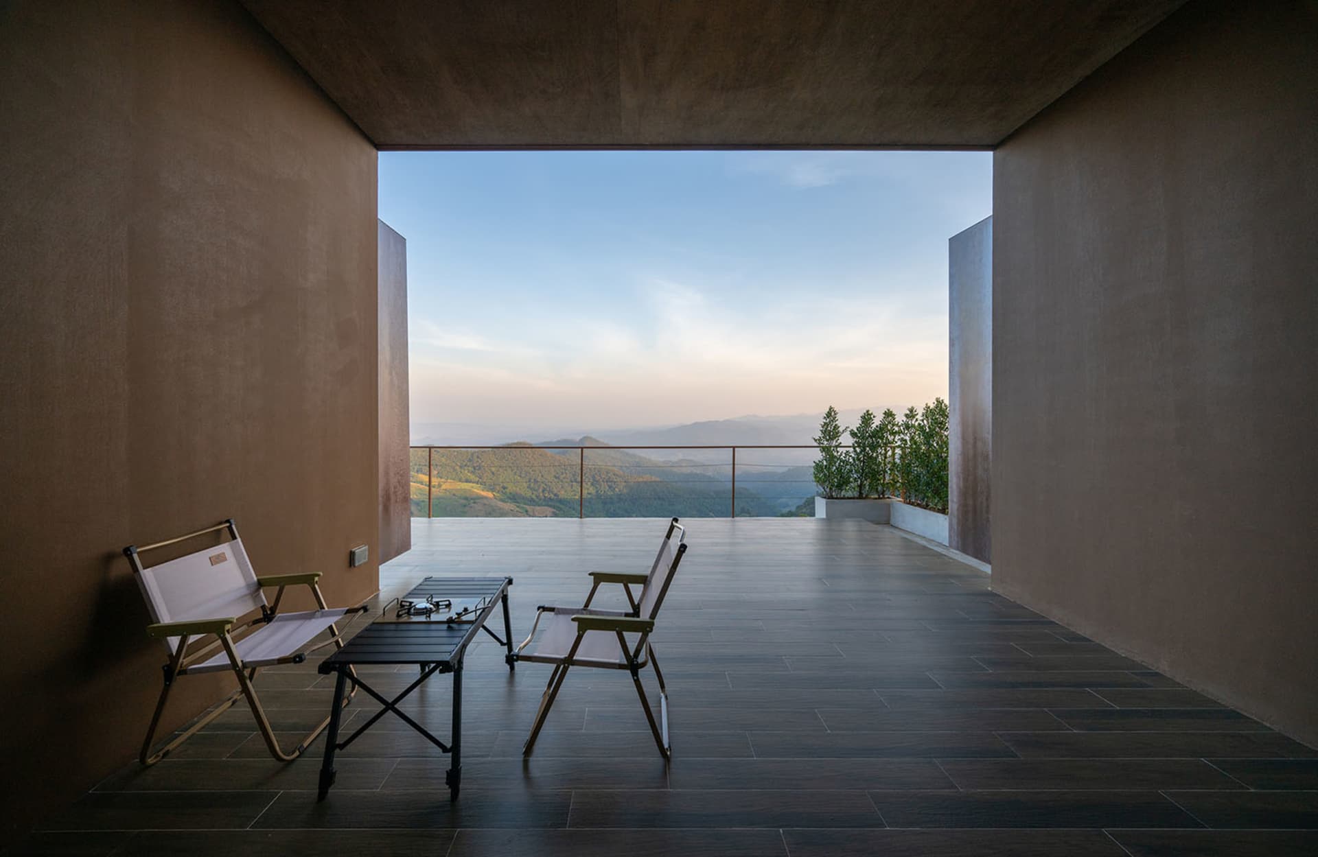 Comfortable living space with a wooden floor, a large window, and a dining table with chairs, well-lit and inviting