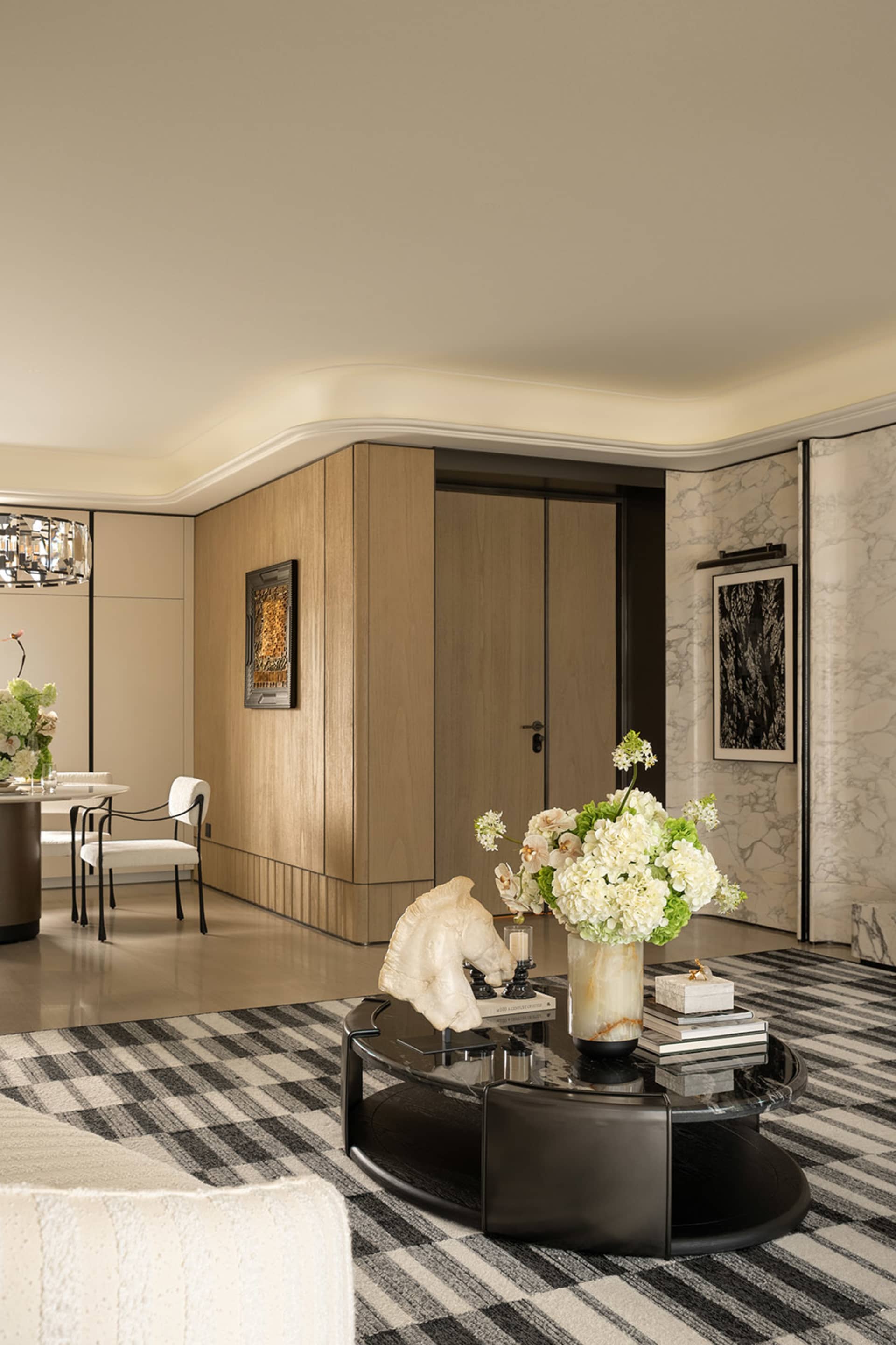 Elegant living room with hardwood floor, marble table, and natural light from a large window