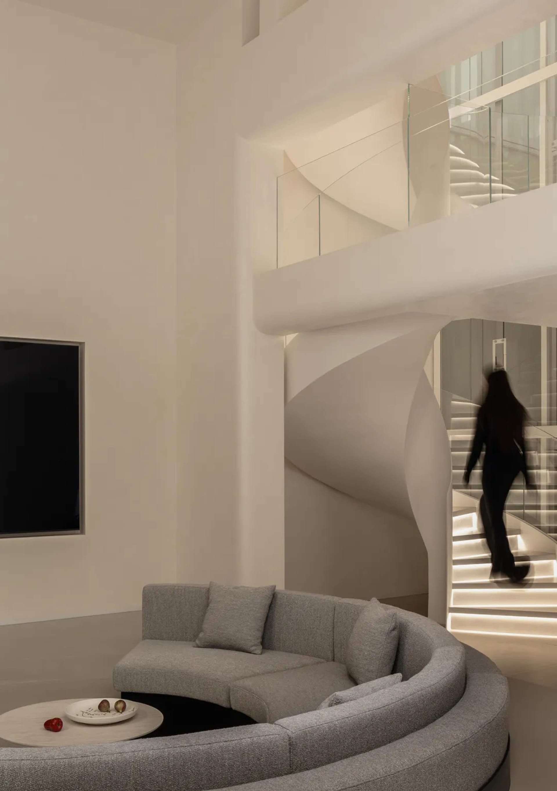 A well-lit living room with a couch, chair, and large window, featuring a modern design with clean lines and minimalistic decor