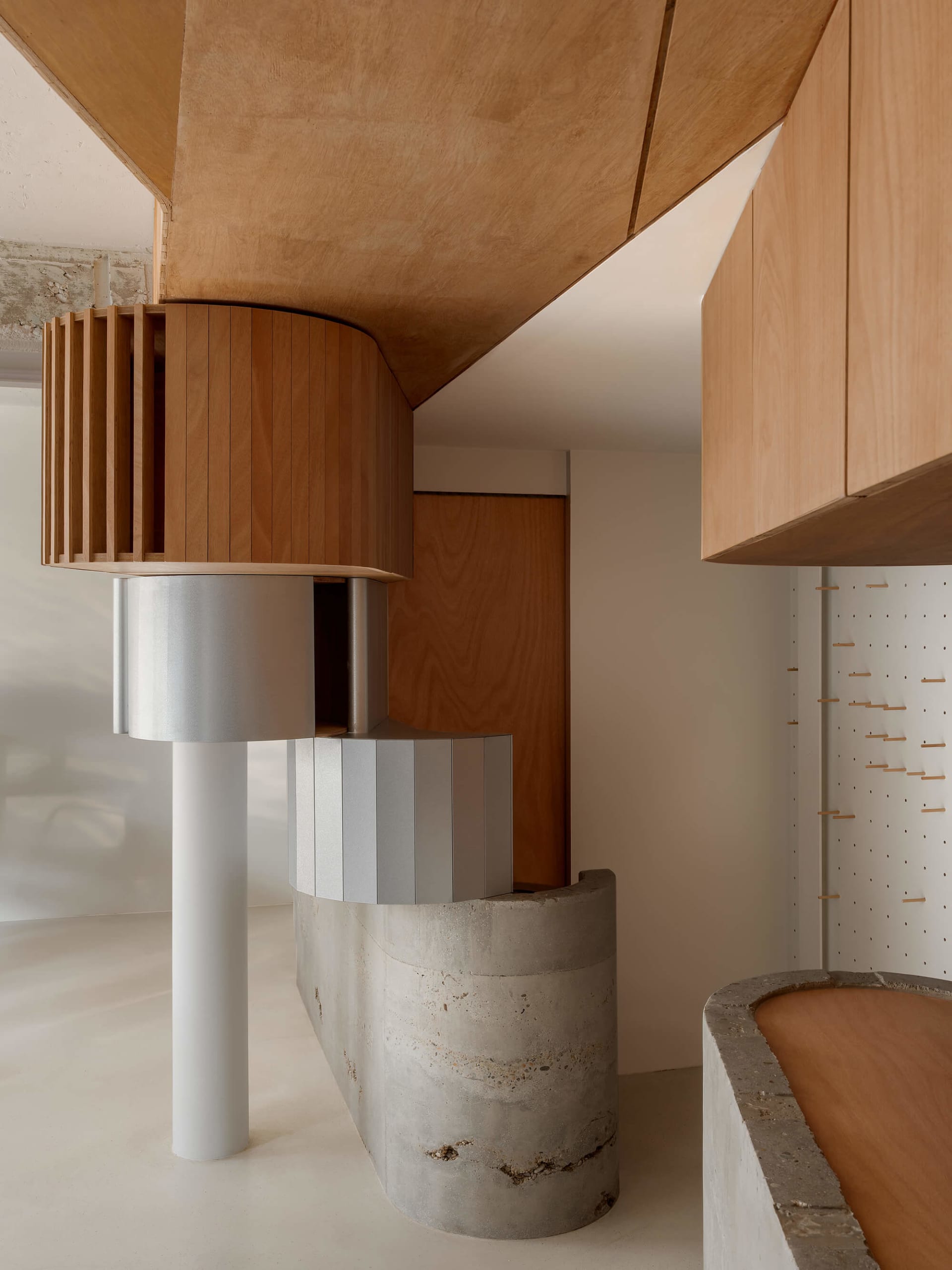 Well-lit kitchen with wooden cabinets, concrete countertops, and a modern design