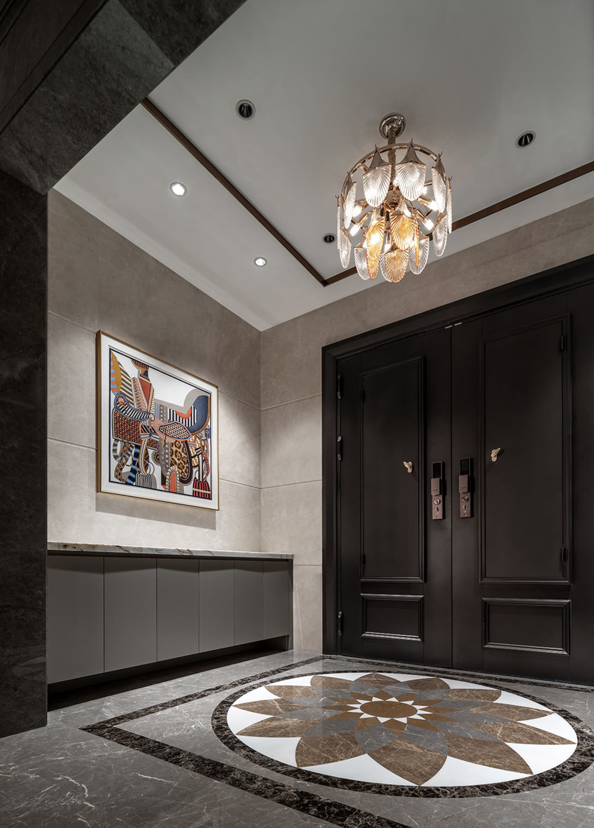 A dimly lit hallway with a chandelier, marble, and wood features, creating a cozy and intimate atmosphere