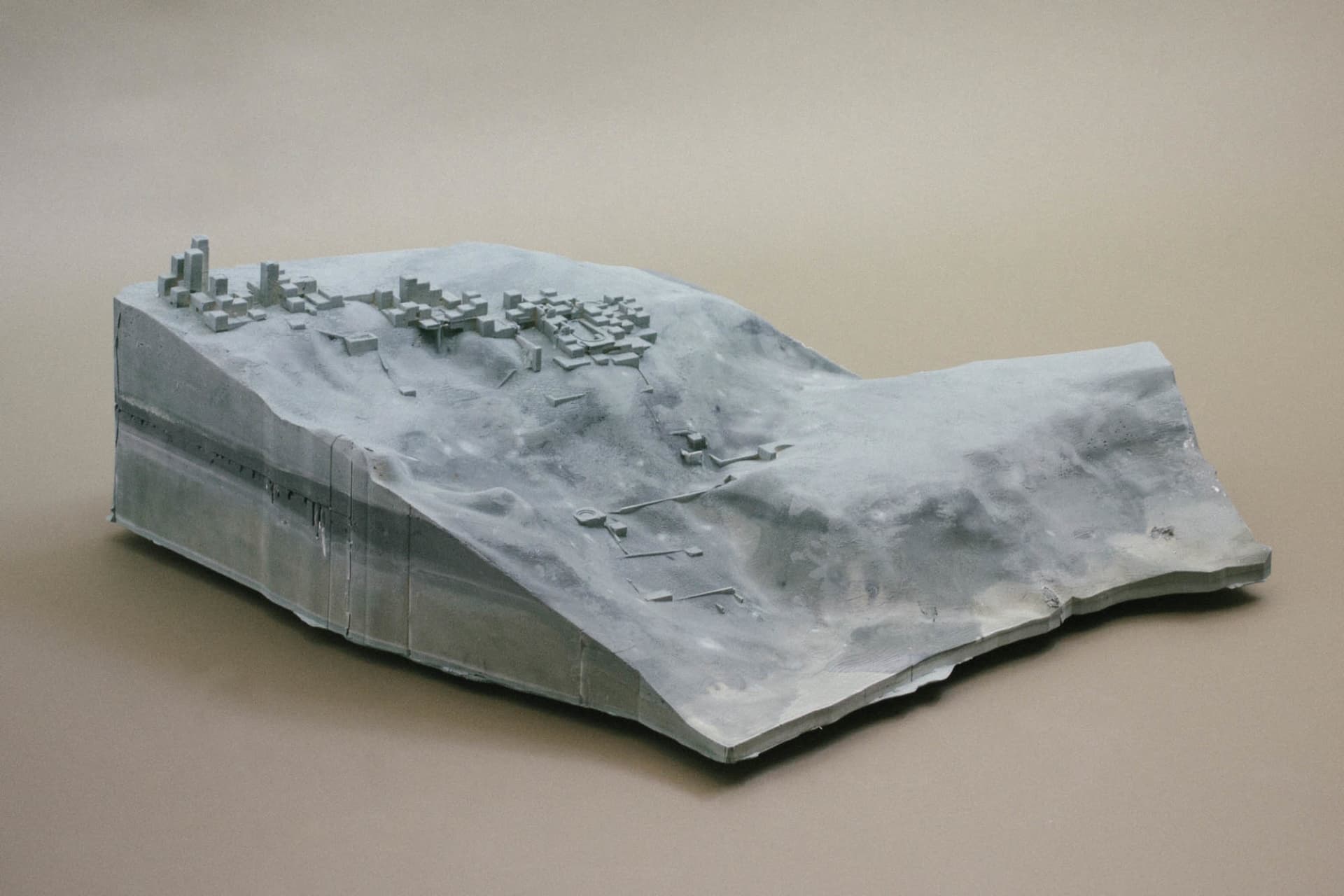 現代城市3D模型，包含多樣建築物，中央有大型結構，周圍環繞較小建築，背景為灰色
